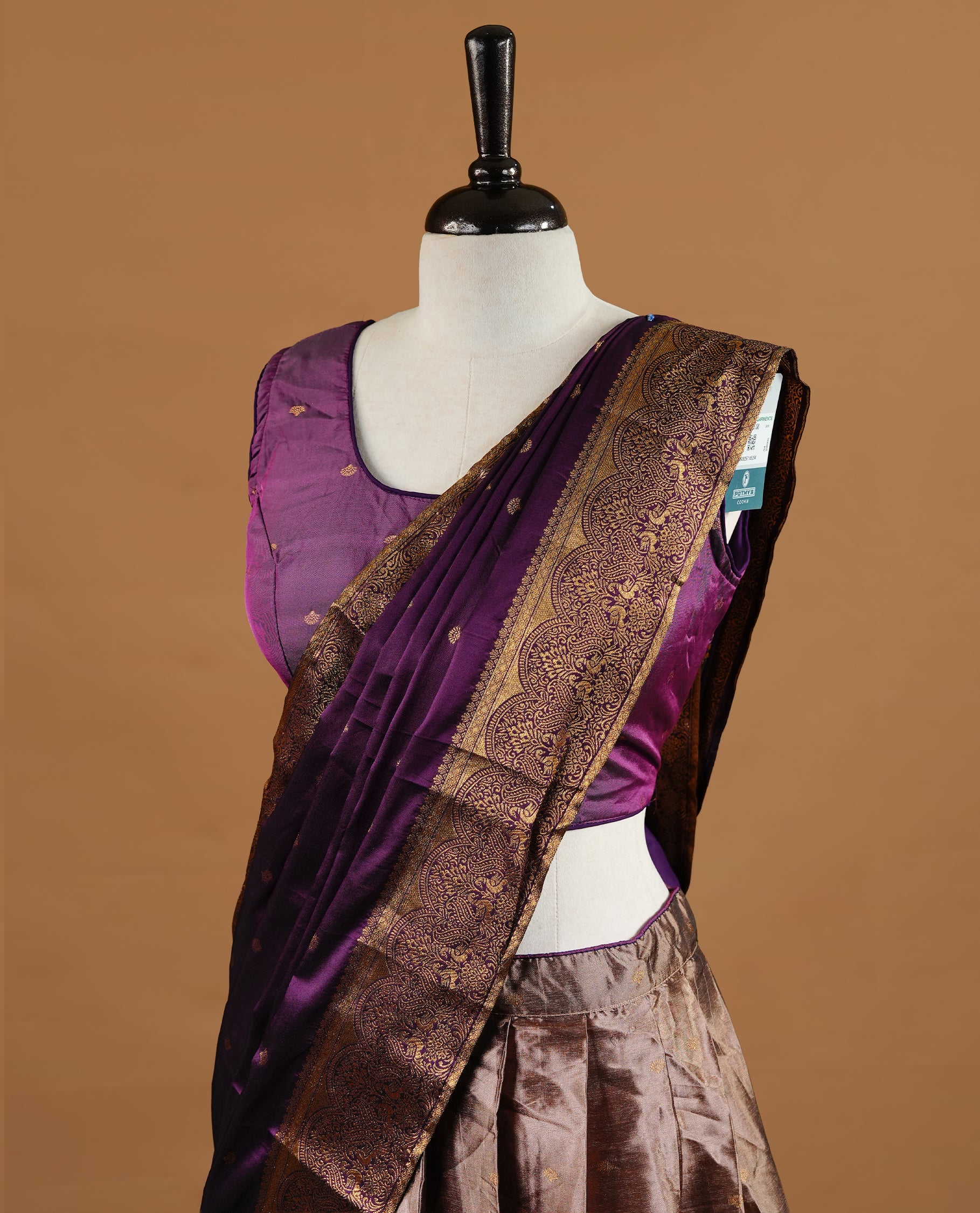 Purple colour Half saree featuring Purple colour skirt with contrast gold colour border with stone work, paired with contrast antique colour stitched blouse piece, with matching dupatta.