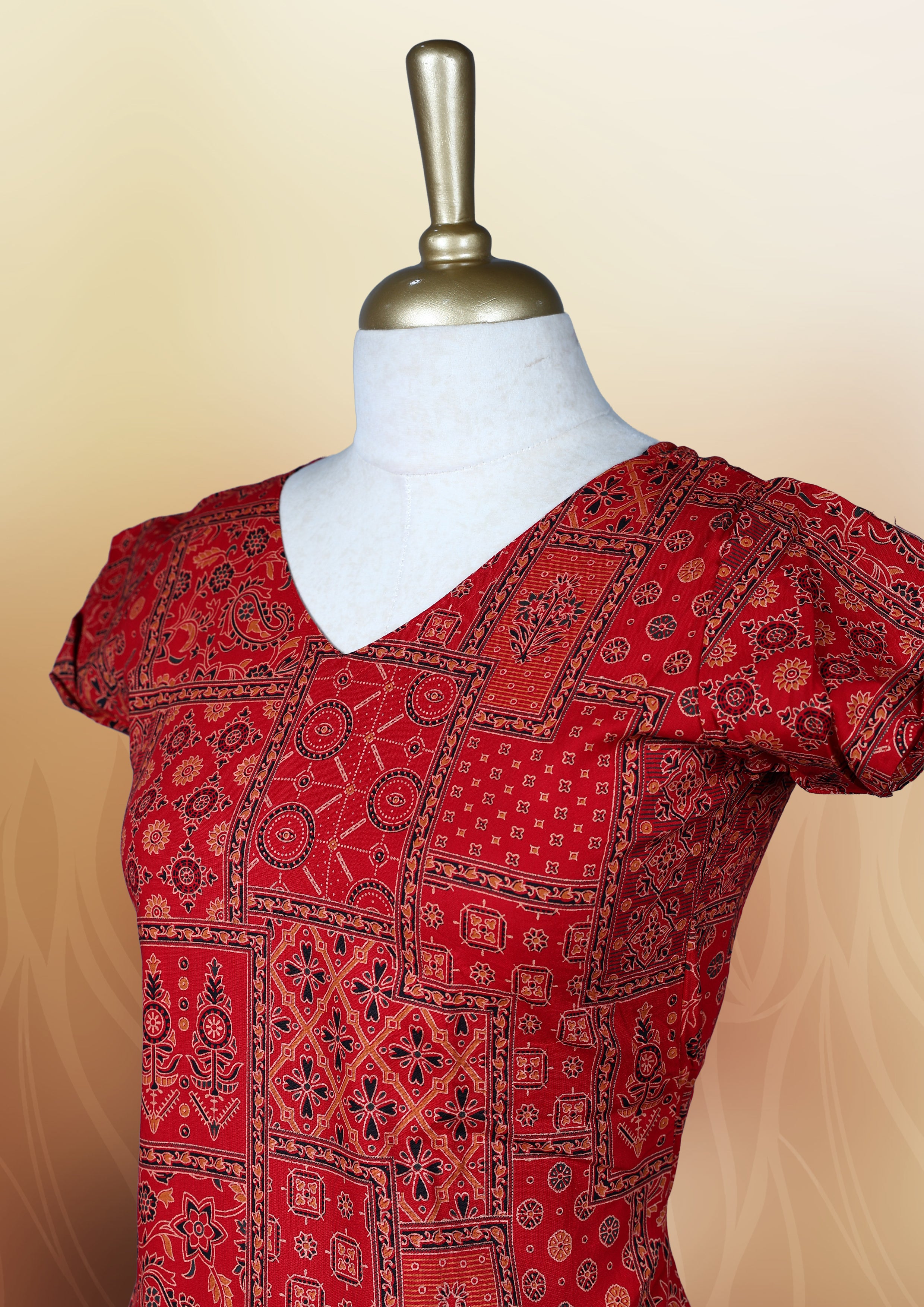 Red colour nightwear with traditional patch style prints in black and white, Features a V neck, puff sleeves, and a ruffled flared hem, A stylish pick for festive occasions, casual wear, or ethnic flair.