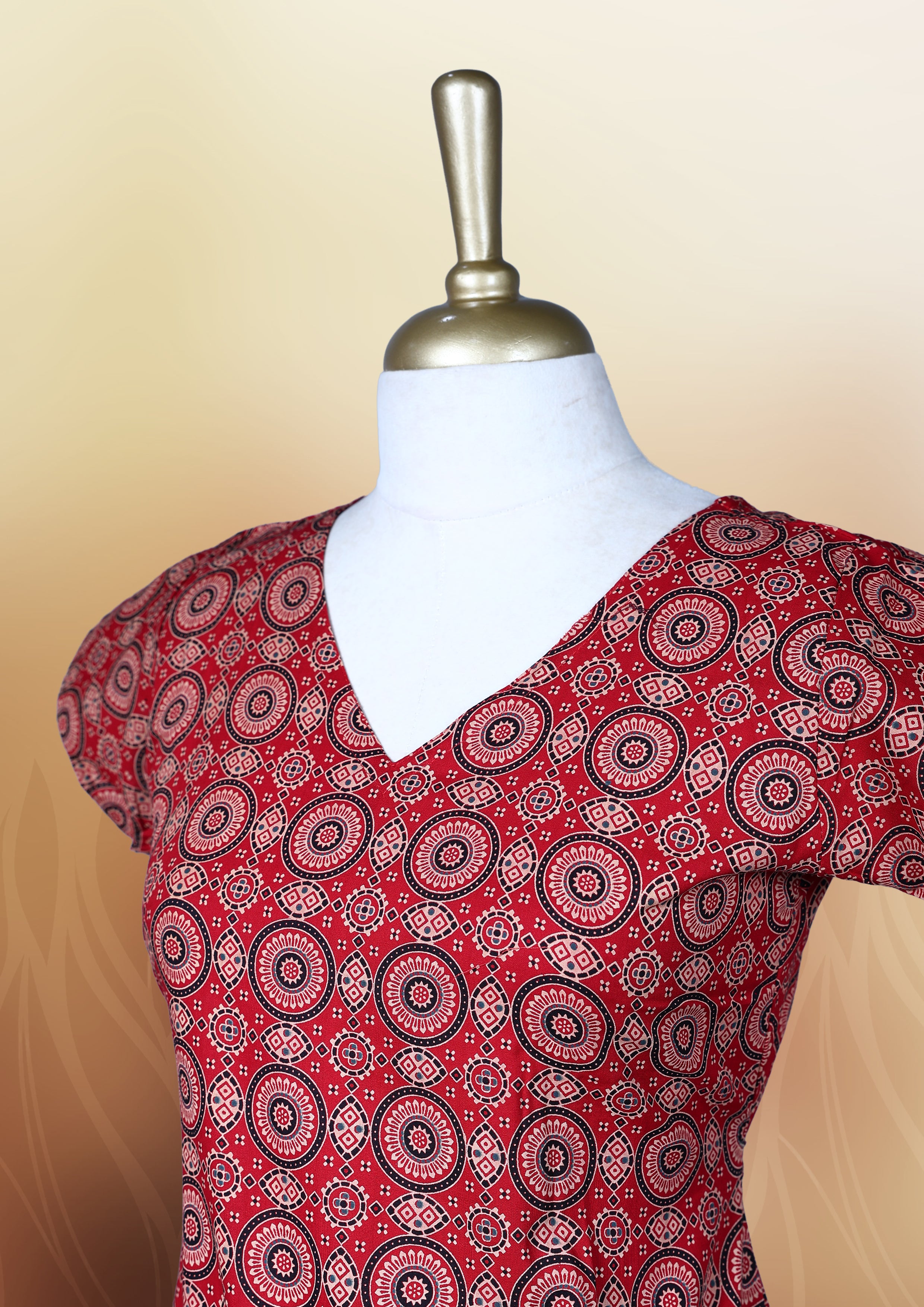 Red colour nightwear with intricate circular patterns in beige and black, Designed with a V neckline, short sleeves, and a flared hemline. Ideal for casual outings, workwear, or ethnic inspired looks.