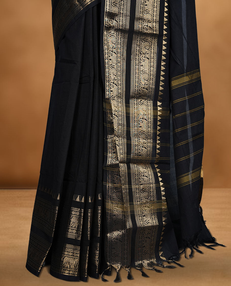Black colour chettinad cotton saree featuring plain body, self colour with traditional gold zari border paired with matching blouse.