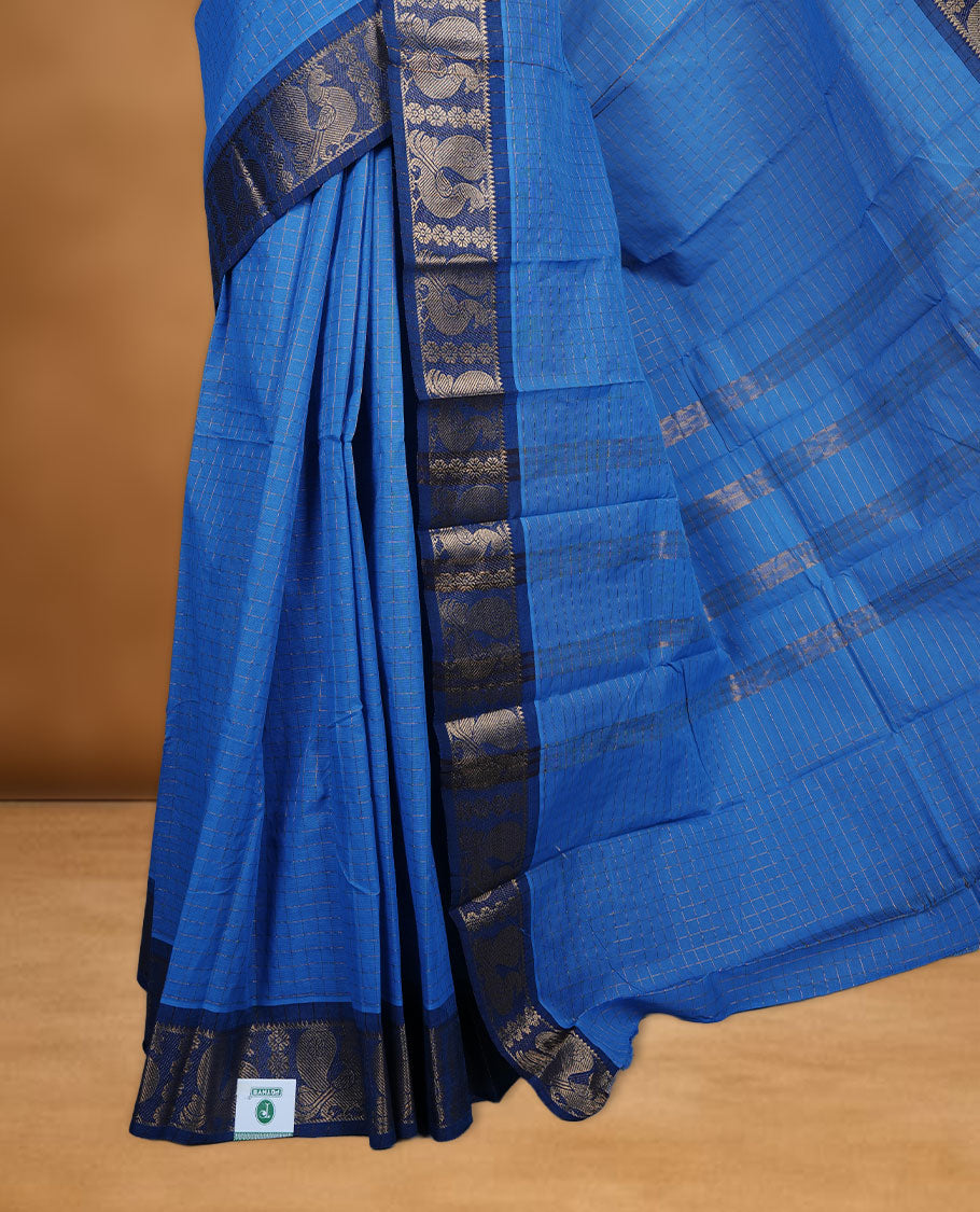 Blue colour sungudi cotton saree featuring gold zari check pattern across body, contrast Dark blue colour with gold zari peacock and floral pattern on border, without blouse piece.