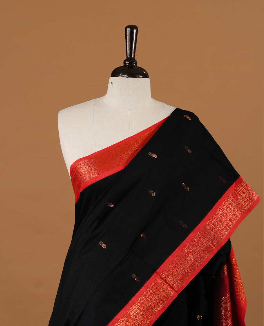 Black colour kalyani cotton saree featuring gold zari motifs on body, highlighting contrast Maroon colour with Antique gold zari border, paired with matching blouse piece.