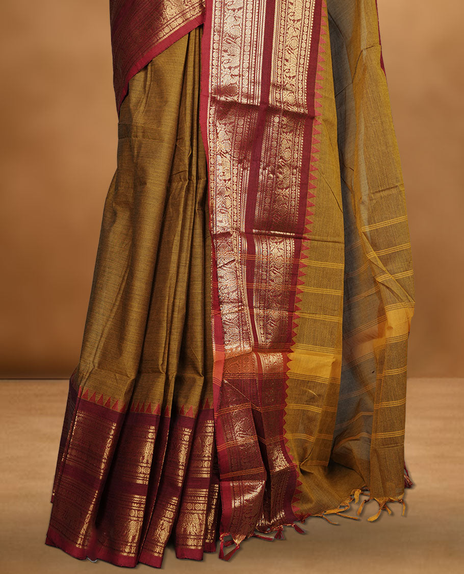 Mustard colour chettinad cotton saree featuring plain body, paired with a black colour traditional gold zari border paired with matching blouse.