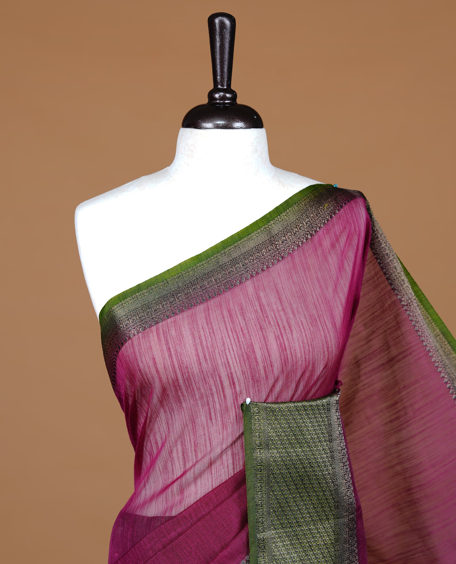 Burgundy colour Semi linen saree featuring Elegant plain body, complemented by contrast Green colour With Antique zari border, paired with matching blouse piece.