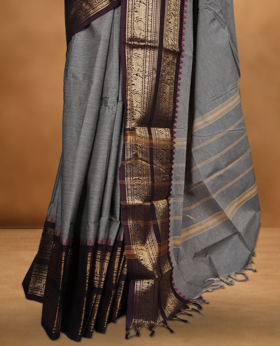 Grey colour chettinad cotton saree featuring plain body, paired with a black colour traditional gold zari border paired with matching blouse.