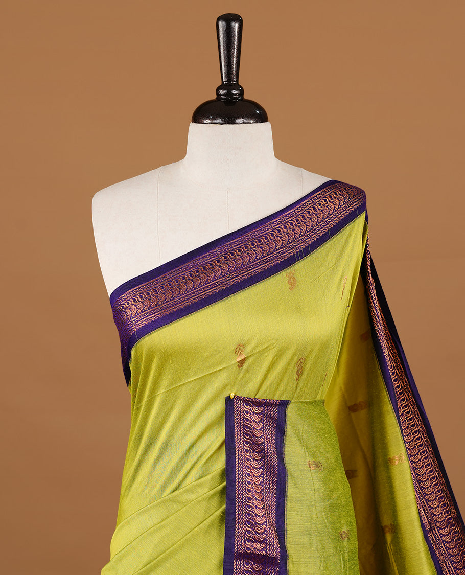 Green colour kalyani cotton saree featuring gold zari motifs on body, highlighting contrast Indigo colour with Antique gold zari border, paired with matching blouse piece.