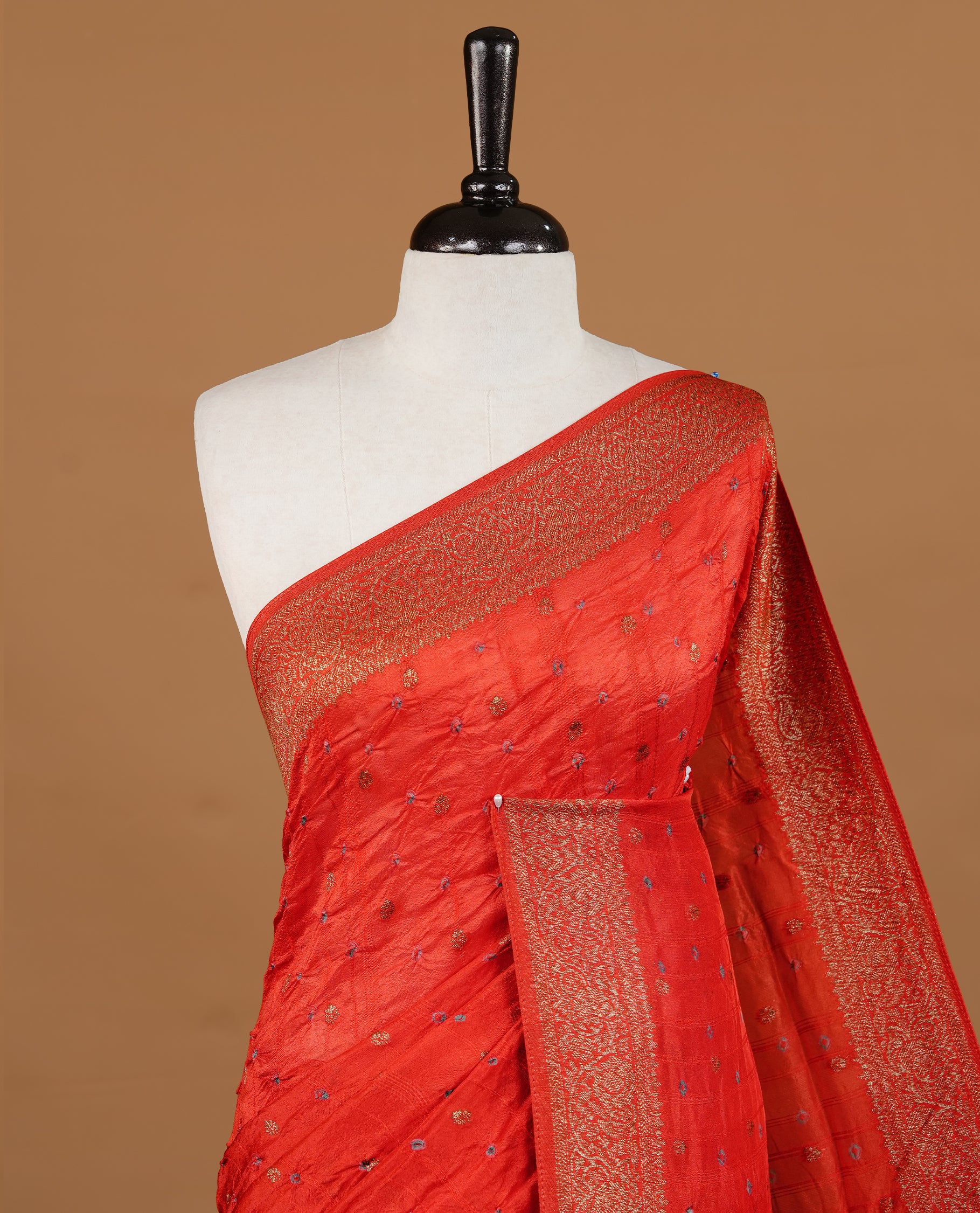 Red colour Banarasi Bandhani silk saree featuring intricate antique zari circle Buttas across the body, complemented by an elegant antique zari border. Comes paired with a matching blouse piece