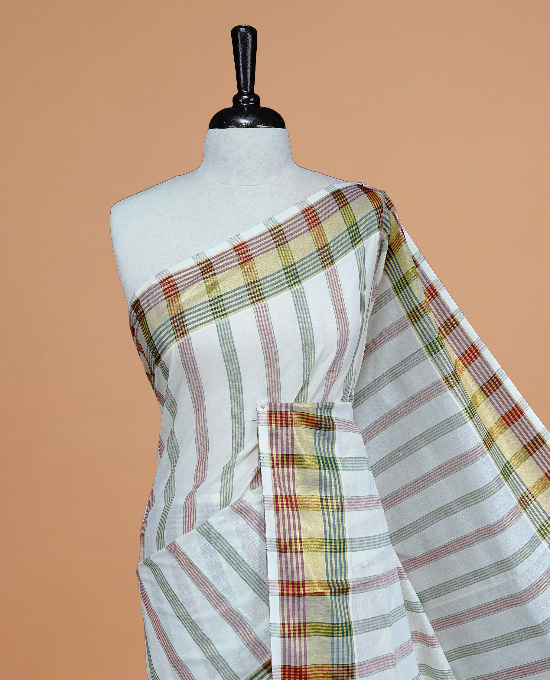 Off white colour Kerala saree featuring Gold with green, Red Zari Strip pattern body, enrich by zari Border, pallu ,comes with matching blouse piece.