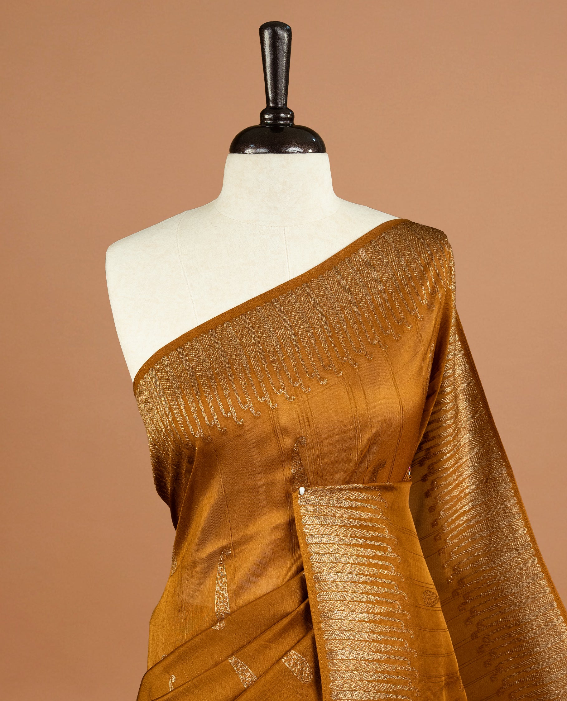 Dark Mustard colour Semi Banaras Tussar Georgette Featuring Gold zari Leaf pattern on body, Finished with Gold zari border and paired with matching blouse piece.