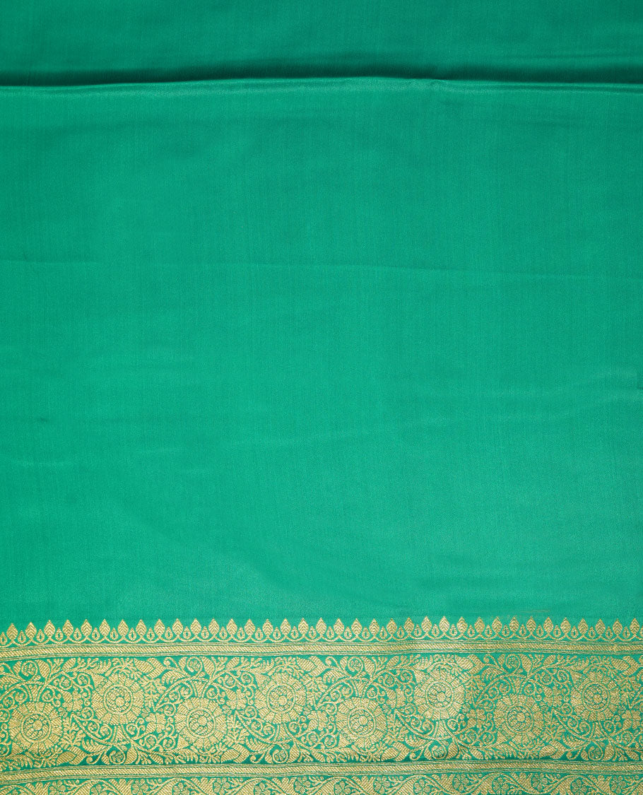 Green colour Banaras Satin Crepe saree featuring gold zari floral motifs on the body, a richly woven traditional border with intricate gold zari detailing, and paired with a matching blouse.