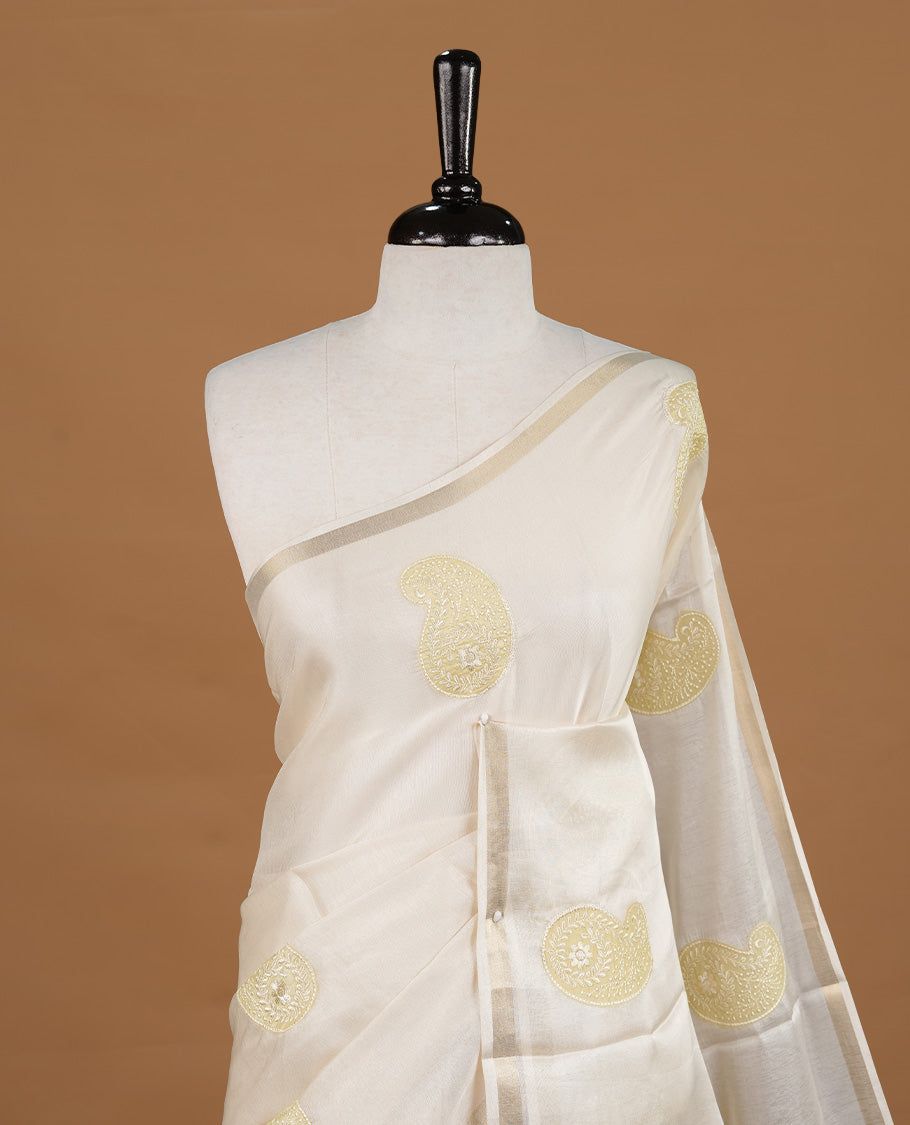 Cream colour Tussar saree featuring yellow colour Mango pattern with chikankari embroidery work, highlighting gold zari simple border, paired with matching unstitched blouse.