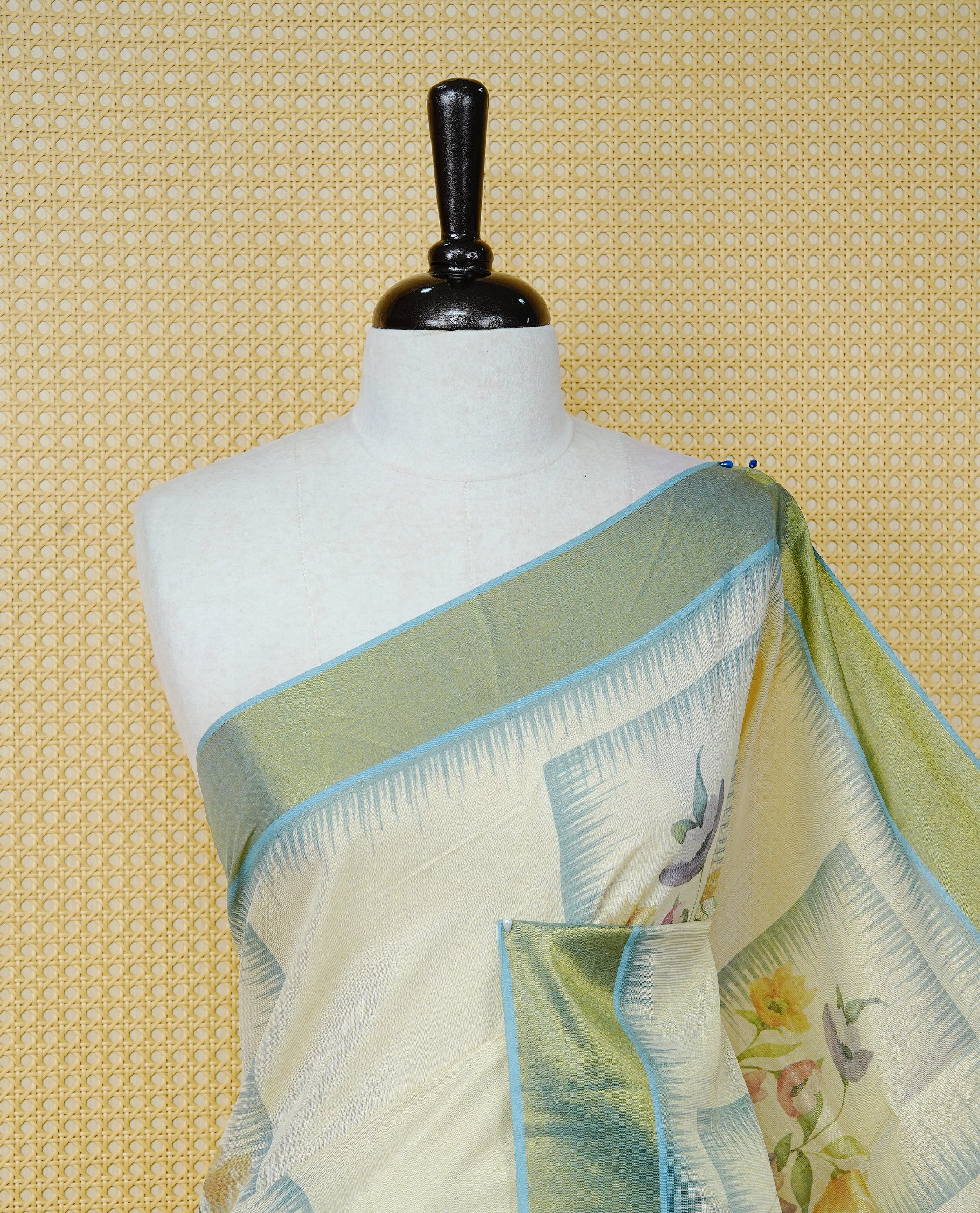 Cream Colour Tissue Kerala Saree Featuring Floral Prints in a Stylish Rectangle Pattern On Body, Enhanced with an Olive Green and Light Blue Zari Border, Multicoloured Striped Pallu Is Finished with Elegant Tassels and Paired with a Matching Blouse Piece.
