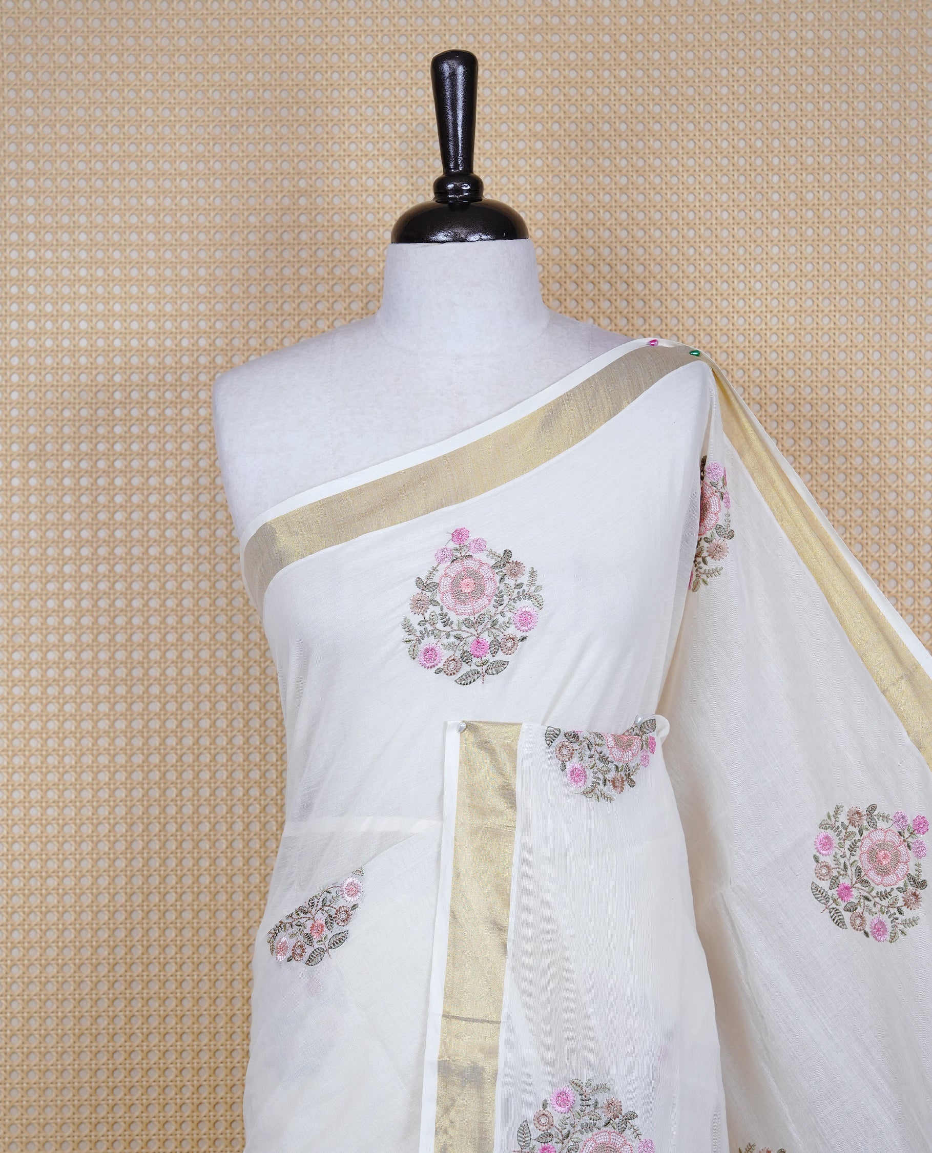 Cream colour cotton Kerala saree featuring Floral Thread work buttas body, complemented by gold kasavu Border, comes with matching blouse piece.