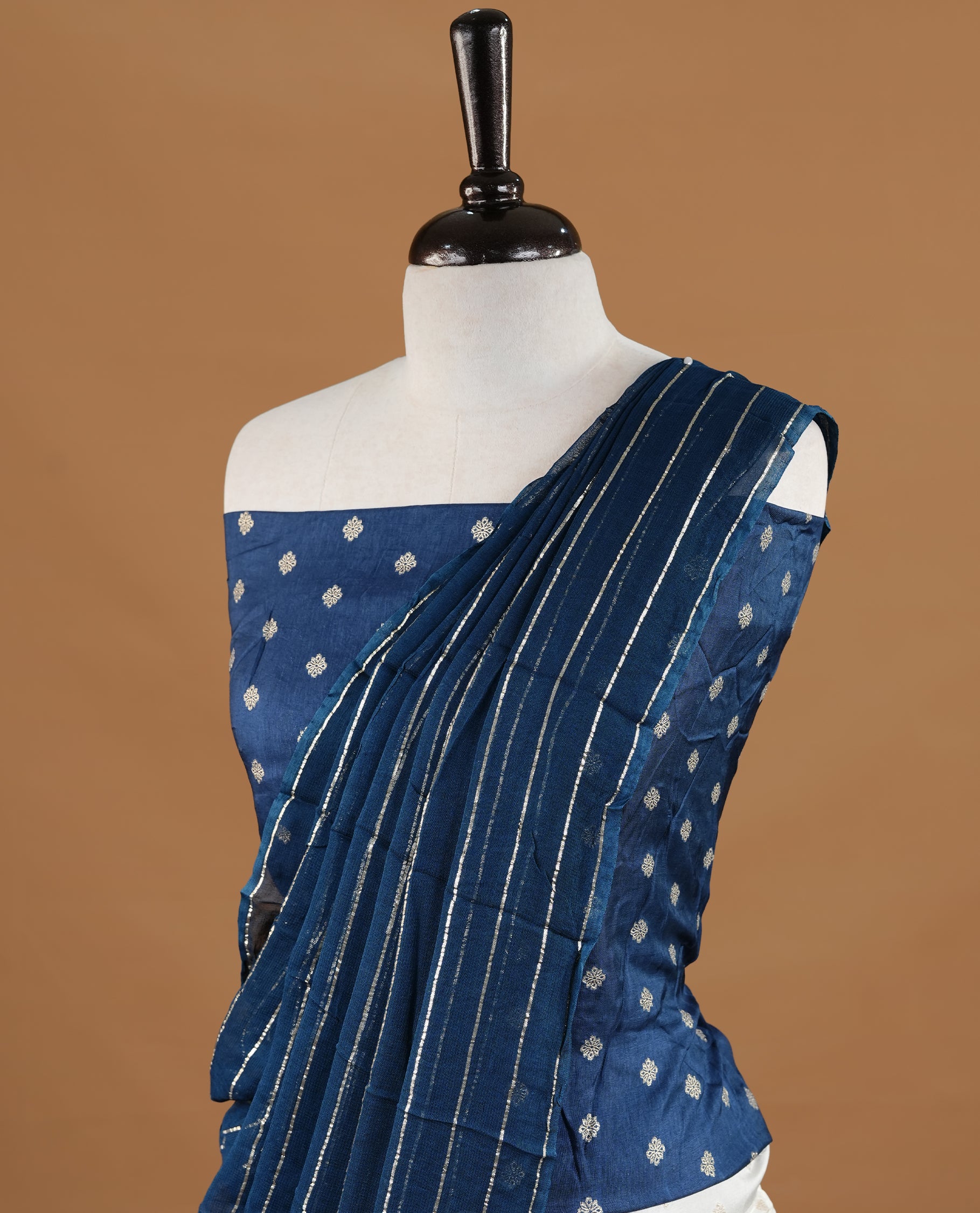 Off white colour semi stitched half saree featuring elegant zari buttas on the body, paired with a contrast blue border and matching motifs dupatta,paired with matching blouse piece.