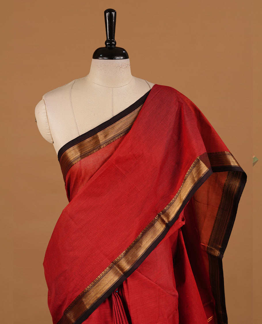 Dark red colour chettinad cotton saree featuring Plain body, complemented by Chocolate with zari border, paired with matching blouse piece.