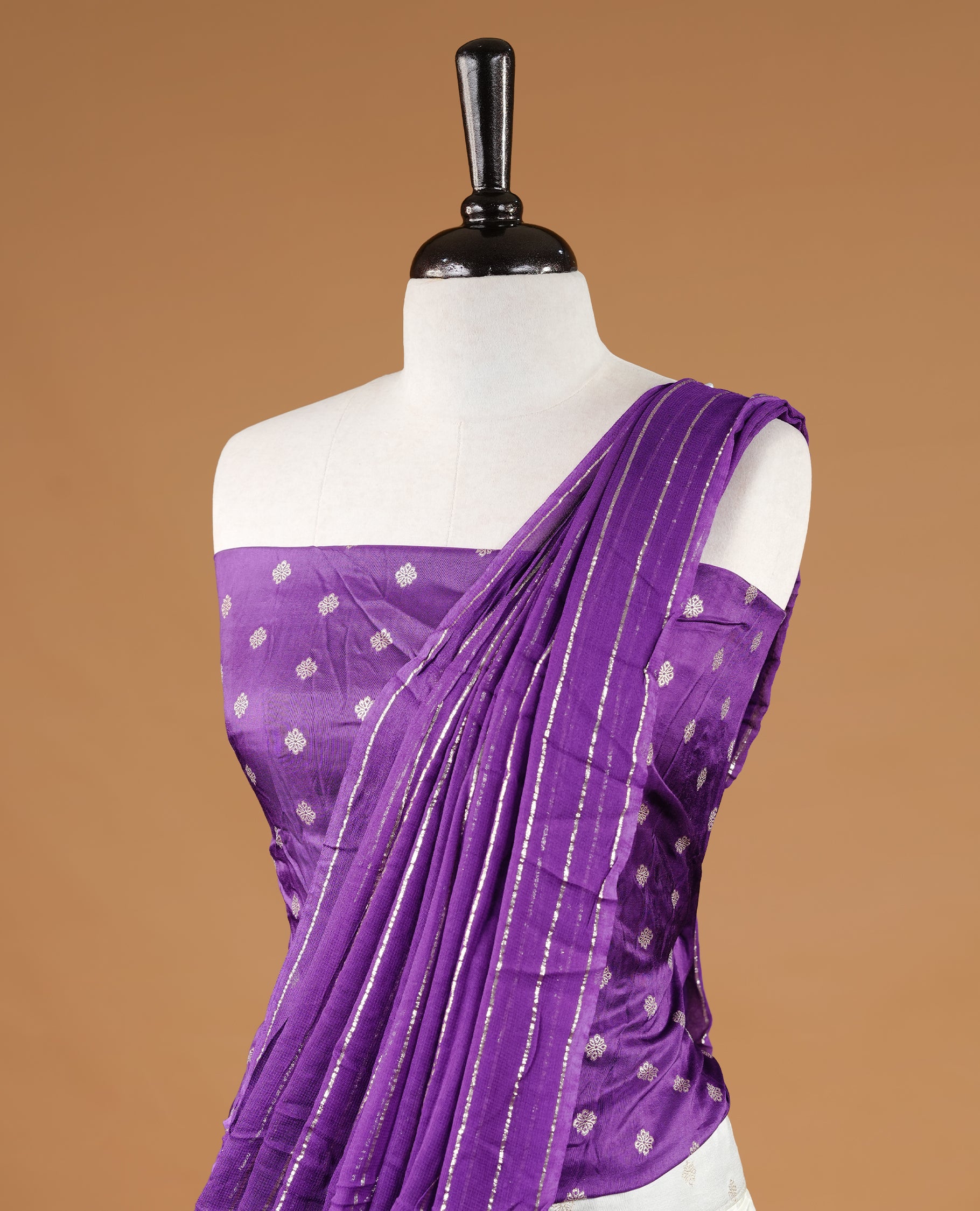 Off white colour semi stitched half saree featuring elegant zari buttas on the body, paired with a contrast purple border and matching striped dupatta,paired with matching blouse piece.