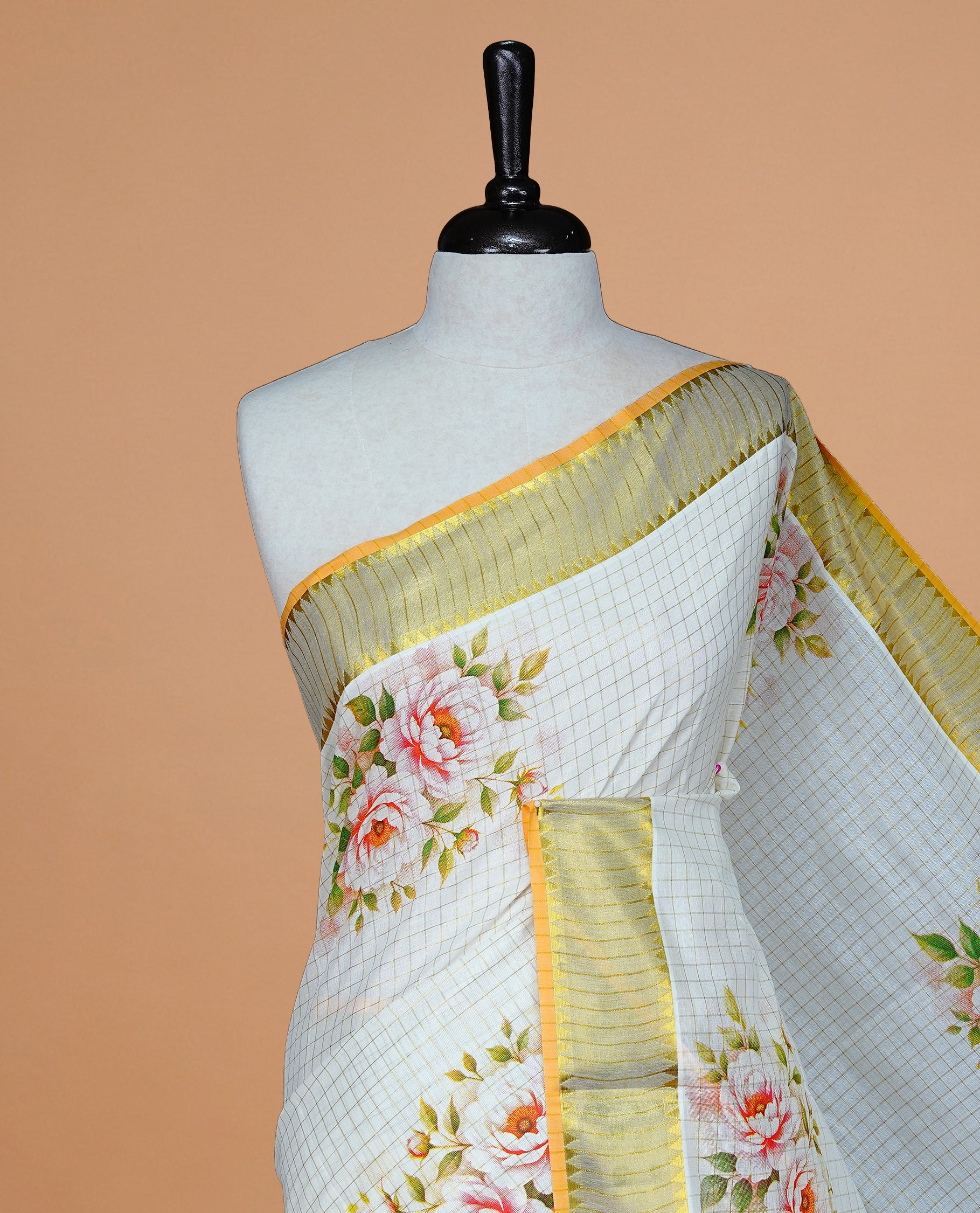 Cream color kerala saree featuring Gold zari Checks on body, enrich Gold zari with floral printed border & pallu, paired with matching blouse piece.