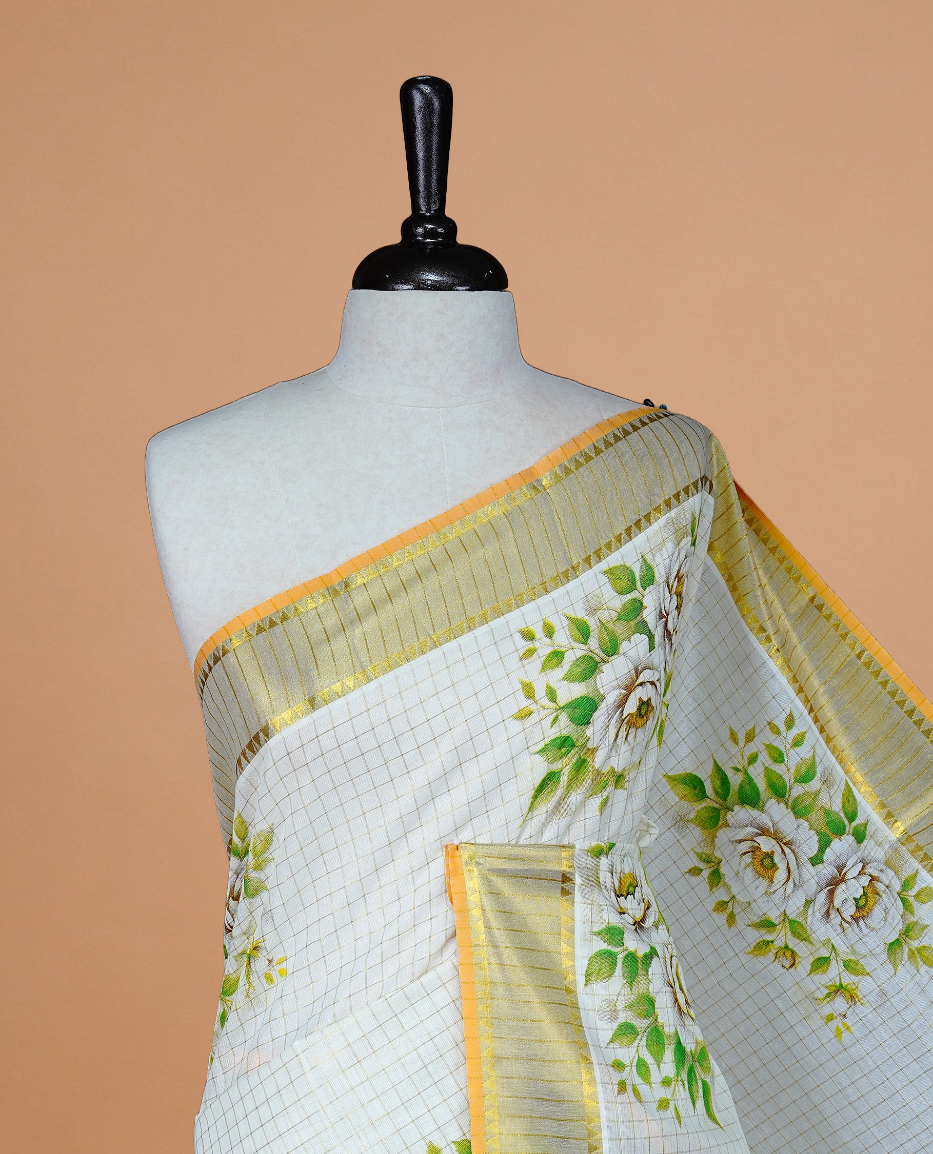 Cream Colour Kerala Saree Featuring Golden Checks On The Body, Complemented By A Traditional Gold Zari & Floral Printed Border, Paired With A Matching Blouse Piece.