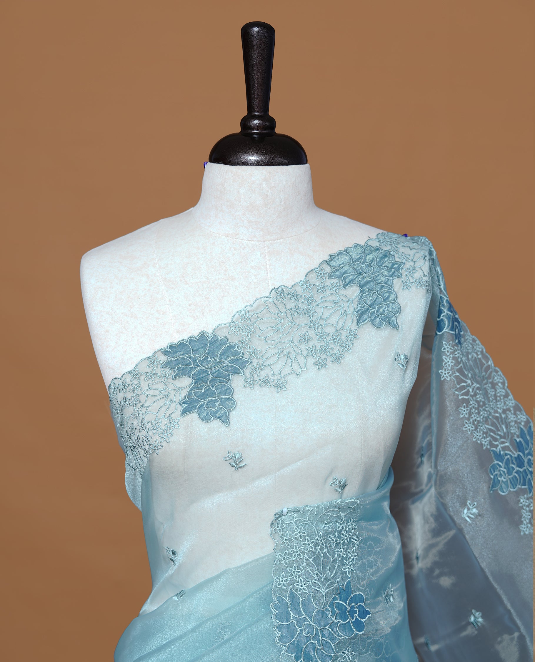 Pastel Blue colour Pure Organza Featuring Self colour Embroidery motifs on body, Enriching floral thread pattern & scalp border, paired with matching blouse piece.
