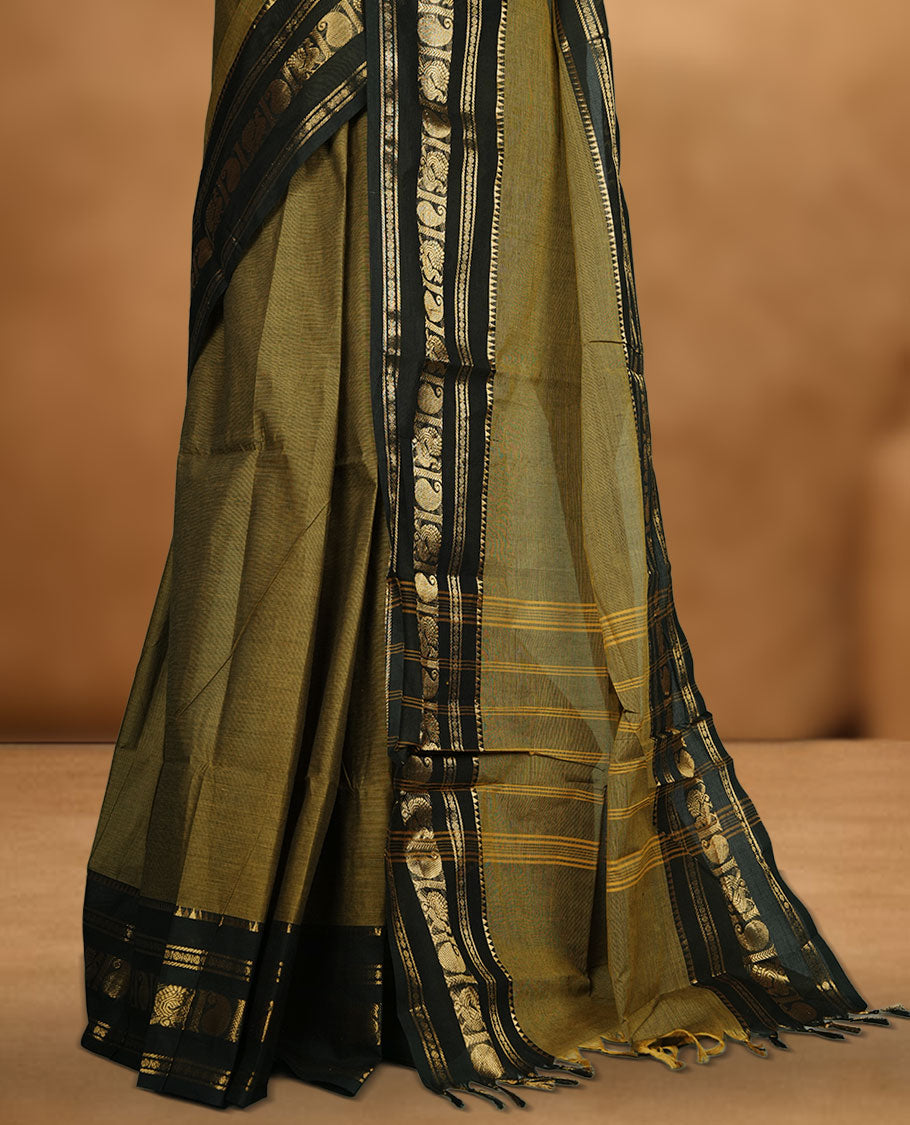 Mehandi colour chettinad cotton saree featuring plain body, contrast black colour with traditional gold zari border paired with matching blouse.