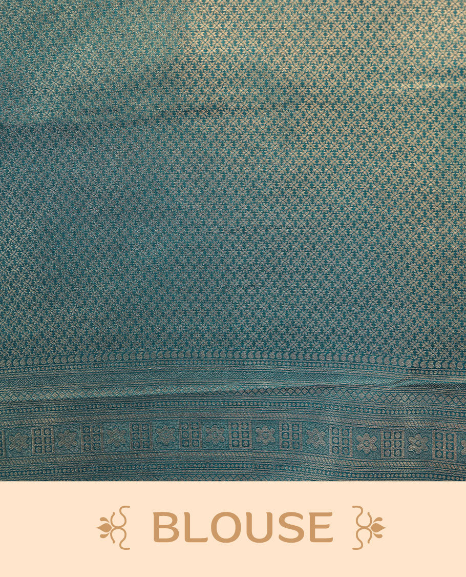 Peacock blue colour semi soft silk brocade saree featuring elegant gold zari floral and paisley motifs across the body, finished with a richly woven self-colour border and pallu, paired with a matching blouse.