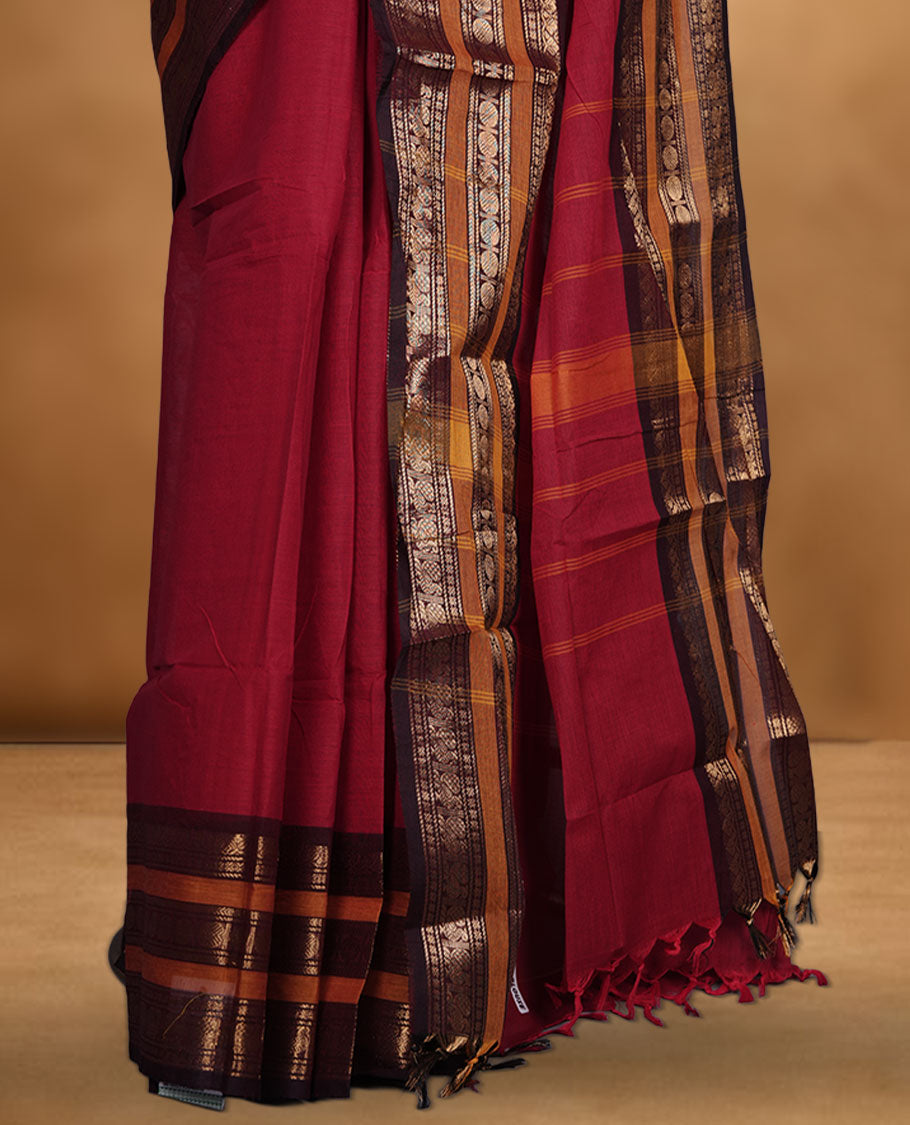 Red colour chettinad cotton saree featuring plain body, contrast chocolate brown and mustard colour with traditional gold zari border paired with matching blouse.