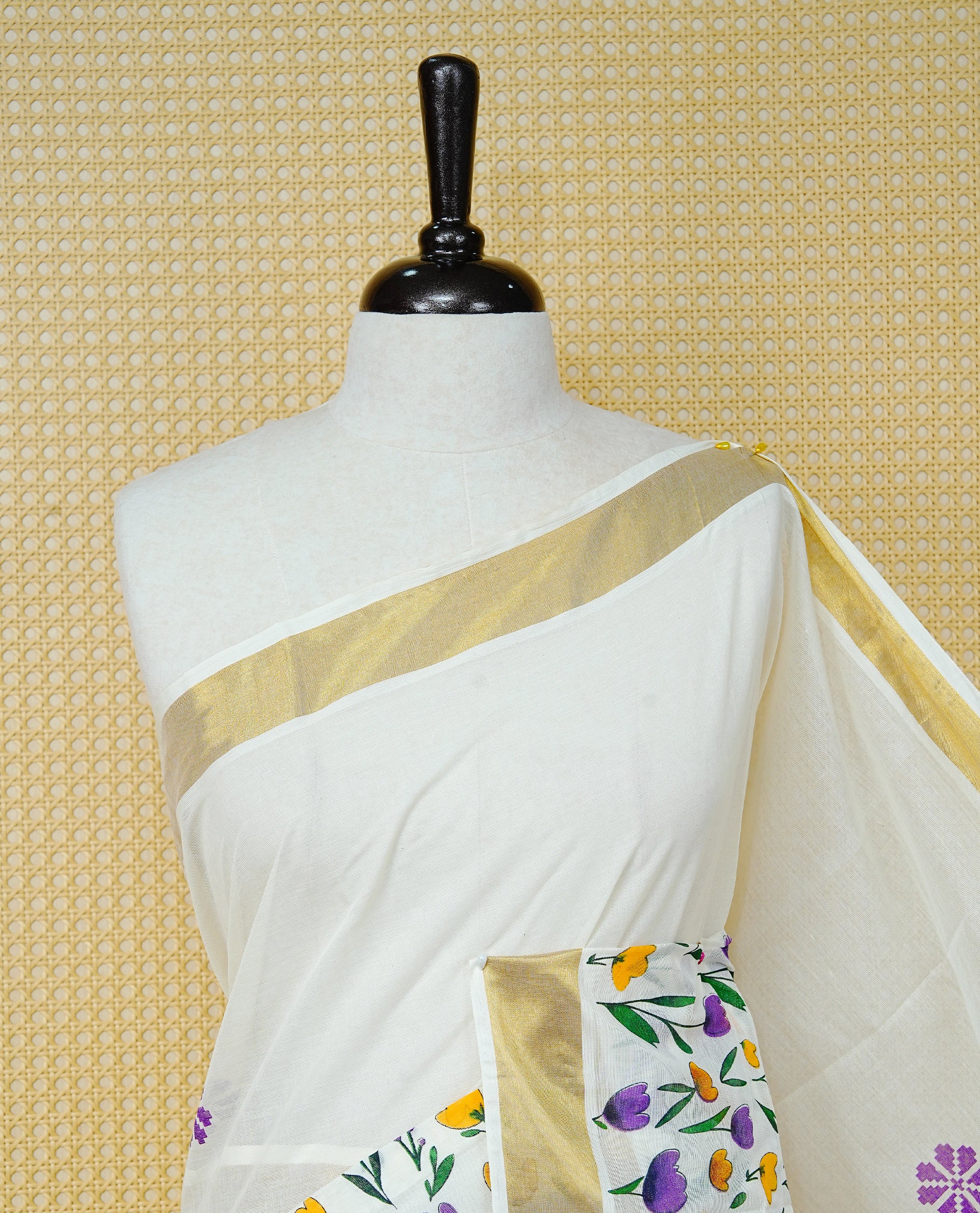 Cream Colour Cotton Kerala Saree Featuring Digital Violet & Yellow Colour Floral Motifs On Body, With A Classic Gold Zari Border & A Gold Zari Pallu, Paired With A Matching Blouse Piece.
