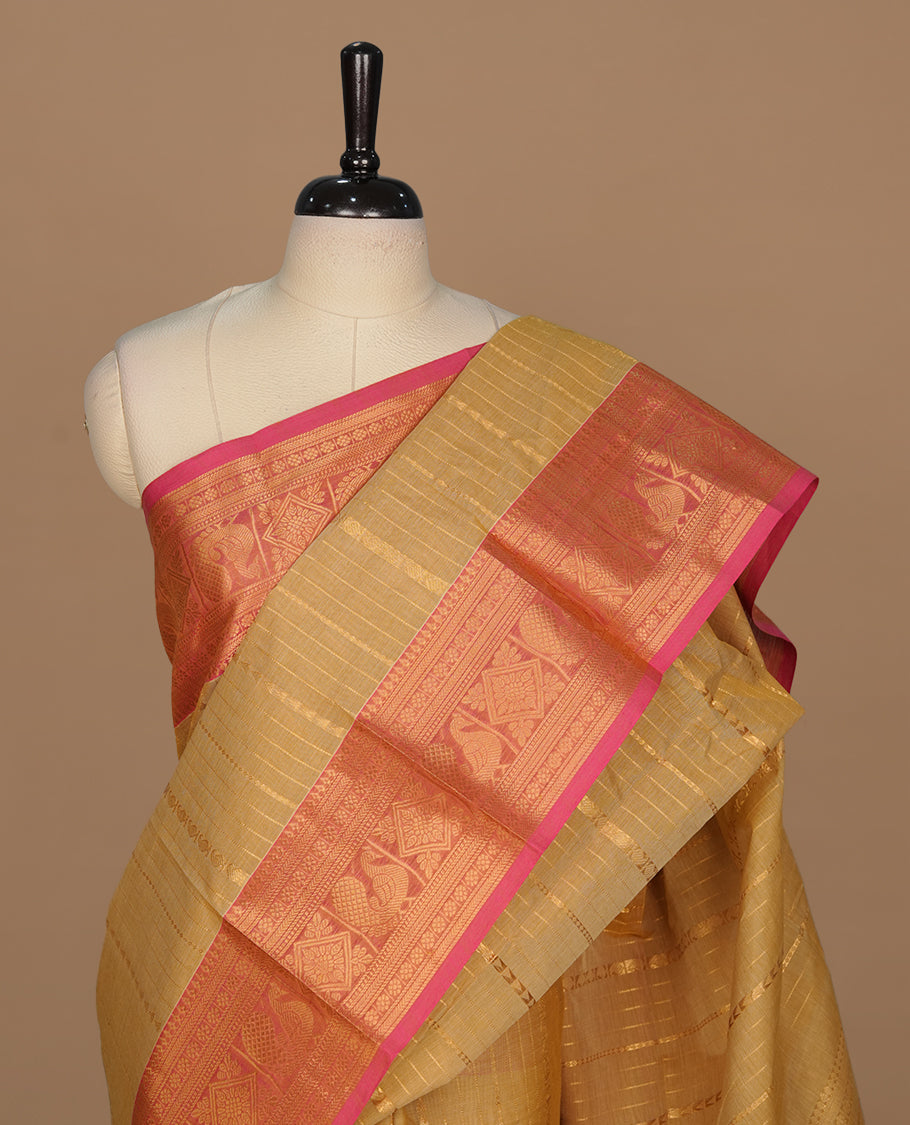 Beige colour chettinad saree featuring gold zari stripes on body, complemented by contrast Magenta colour with traditional border, paired with matching blouse piece.