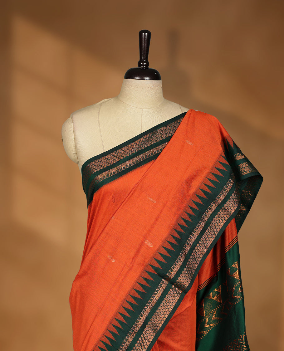 Orange colour kalyani cotton saree featuring Antique zari motifs on body, contrast green colour border with geometric antique zari pattern, paired with matching blouse piece.