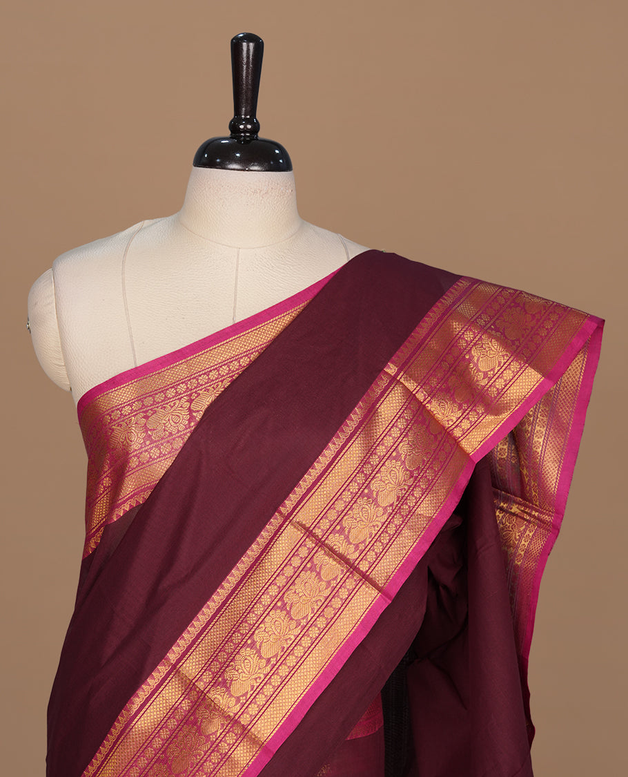 Maroon colour chettinad cotton saree featuring elegant plain body, complemented by contrast magenta colour with gold zari border, paired with matching blouse piece.