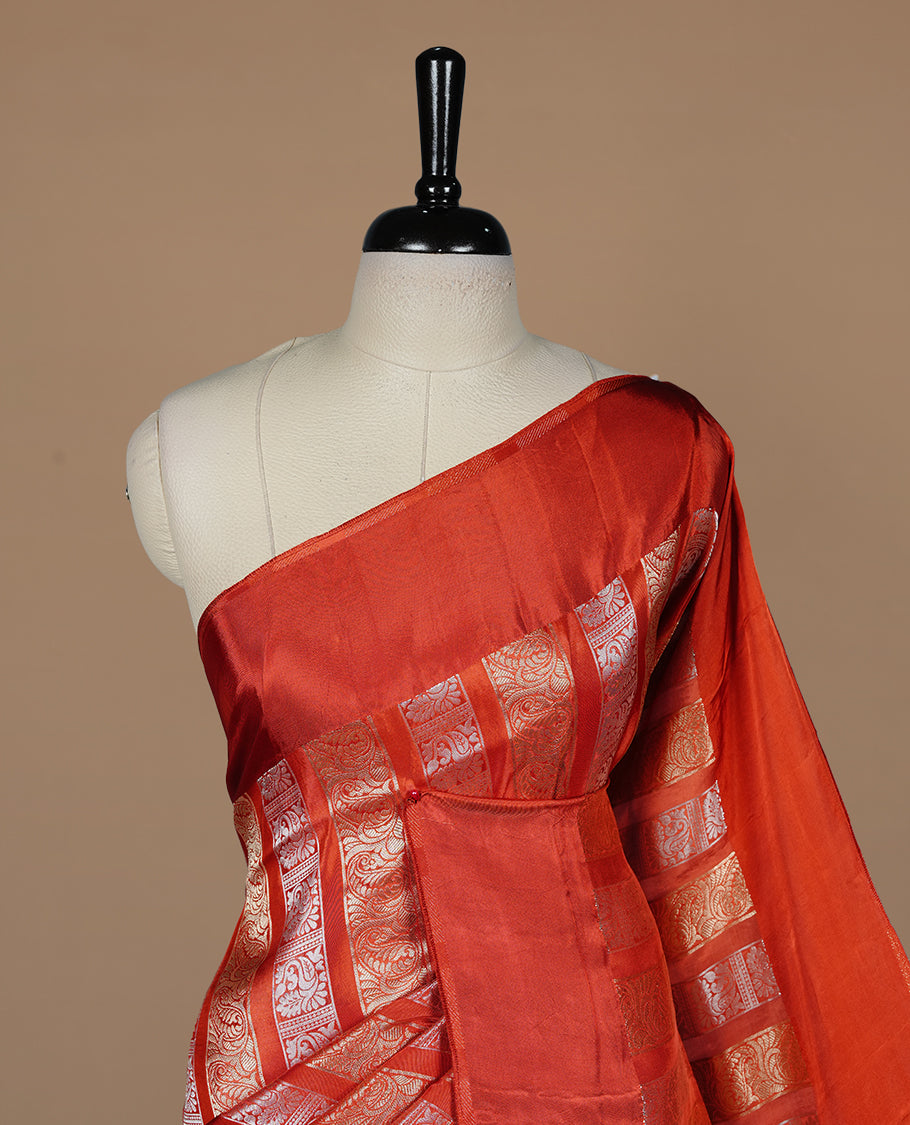 Brick red colour banaras crepe saree featuring gold & silver zari design stripes on body, complemented by self colour border, paired with matching blouse piece.