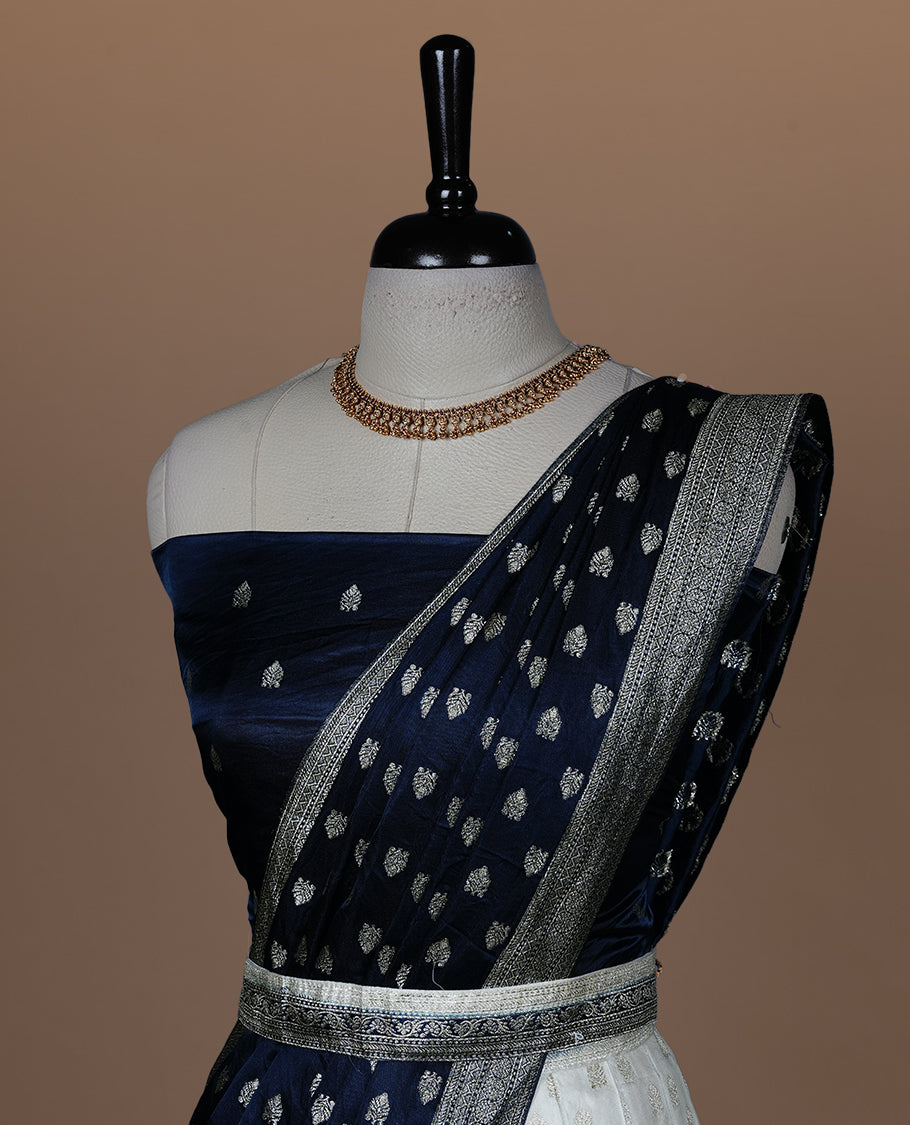 Off white semi banaras semi stitched dhavani set featuring gold zari motifs and contrast Teal colour and traditional border, unstitched gold zari blouse piece and matching Duptta.