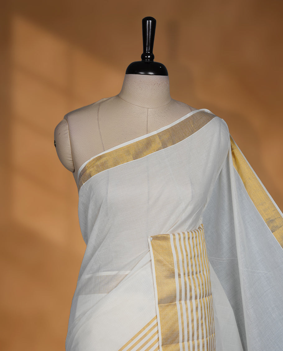 Off white cotton Kerala saree with a plain body, striped golden zari border, and traditional pallu, paired with a matching blouse.