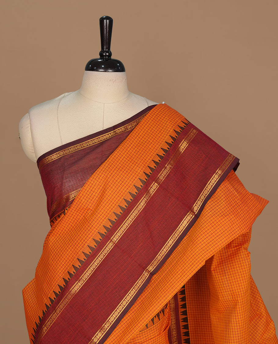 Tangerine colour chettinad colour featuring check pattern on body, complemented by maroon with zari border, paired with matching blouse piece.