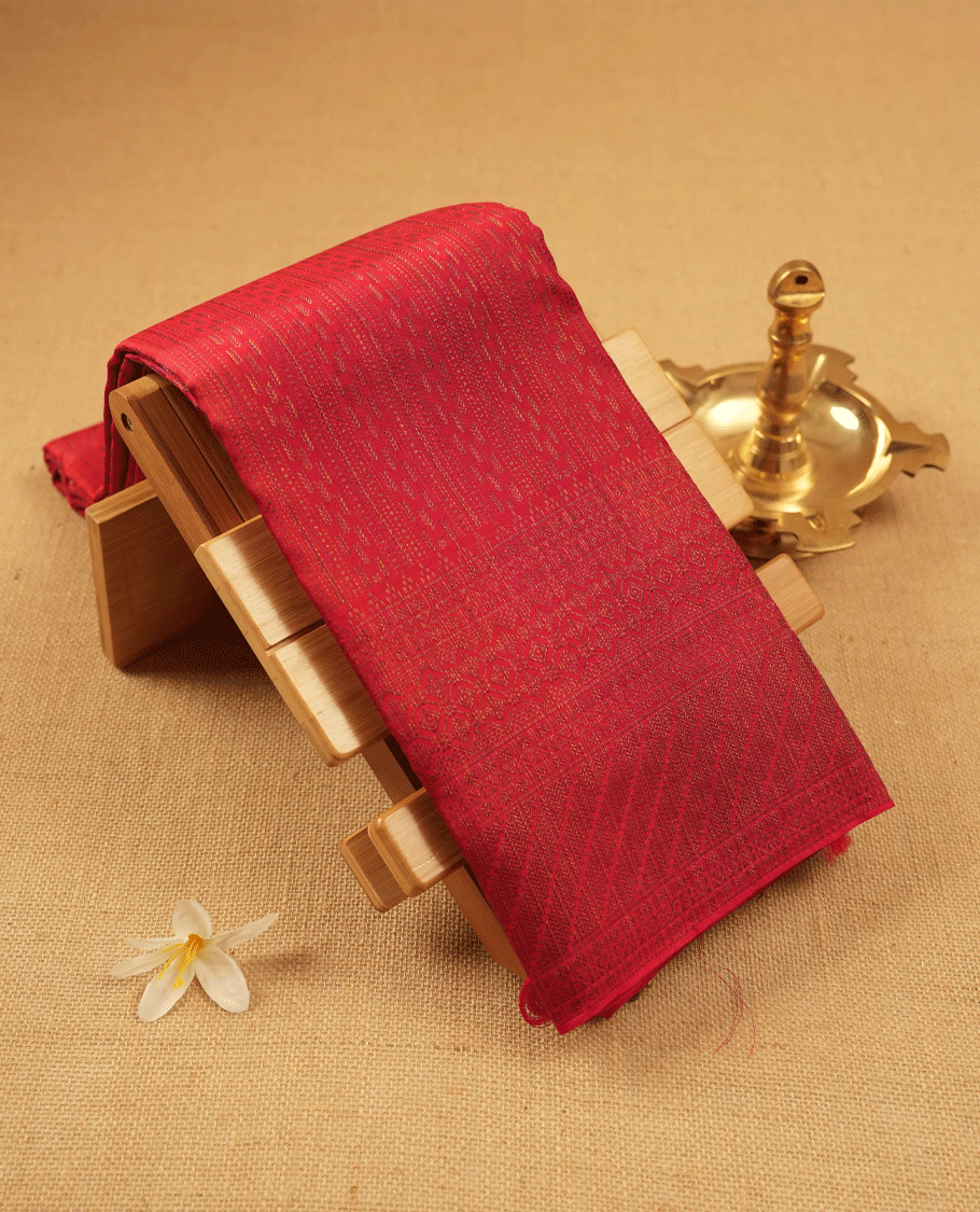 Red coloured Manthrakodi saree featuring a multicoloured zari jacquard body, complemented by a self coloured turning Banarasi border and a matching self coloured blouse.