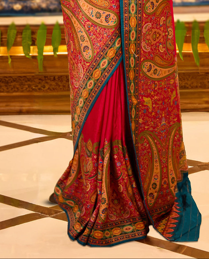 Magenta colour Pashmina silk saree beautifully woven with intricate paisley and floral motifs in vibrant multicolour weaves, framed by teal and gold ornamental borders and an elaborate artistic pallu, paired with a coordinated woven blouse piece.