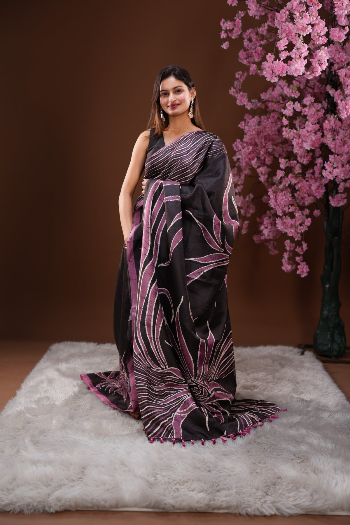 Black colour Semi Khadi Silk Saree featuring a plain black body, complemented by a purple colour geometric pattern on border and paired with a matching blouse piece.
