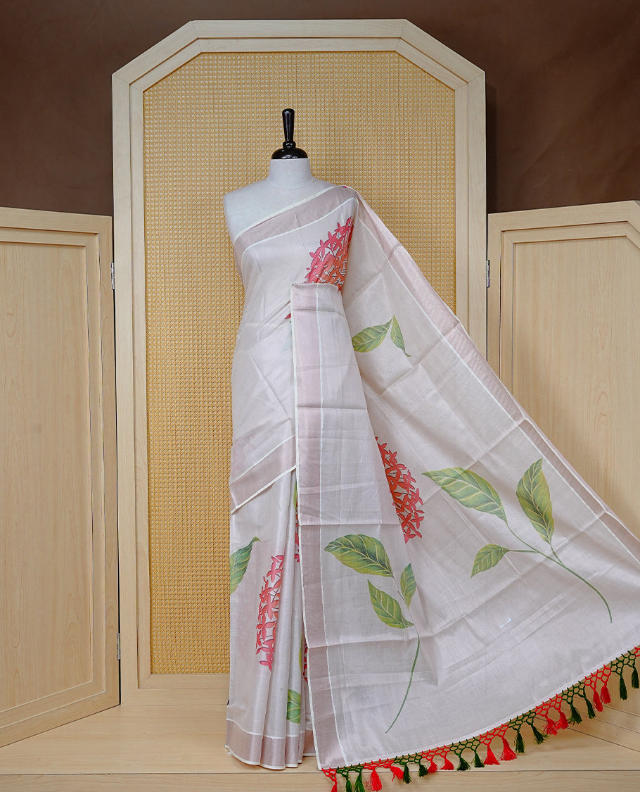 Cream Colour Tissue Kerala Saree Featuring A Digital Floral Printed Body & Pallu, , Beautifully Enhanced With A Classic Rose Gold Zari Border And Red & Green Tassels, Paired With A Matching Blouse Piece.