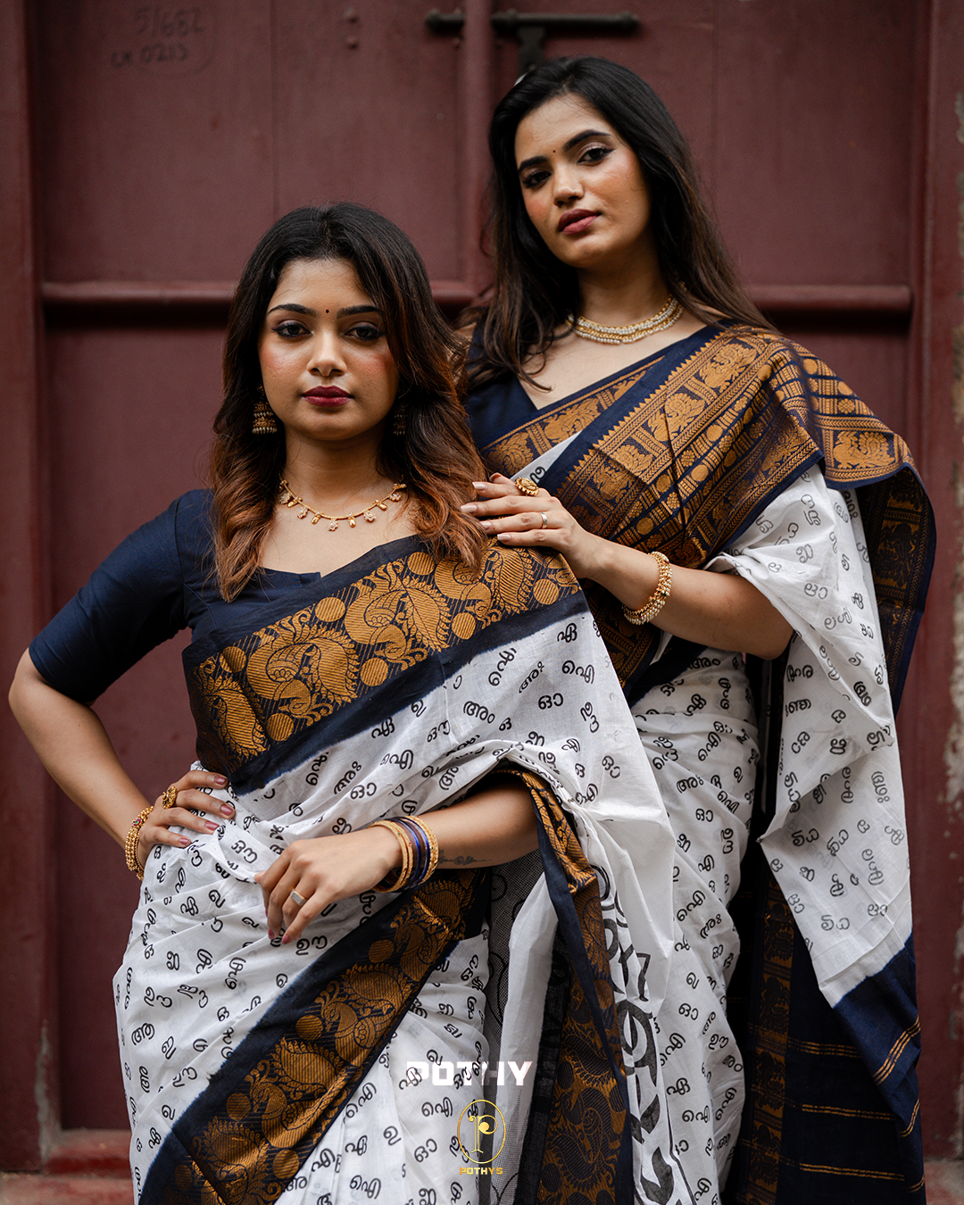 Off White Sungudi Cotton Saree featuring Malayalam alphabets on the body, a navy blue border with gold zari peacock and chakra motifs, a self-colour pallu with floral prints, and a matching blouse piece.