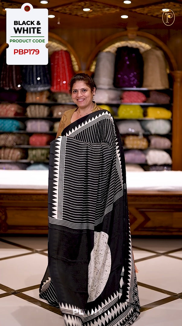 Black semi modal crepe saree featuring white vertical line prints, accented with a temple border and Bold circle Motif design on the pallu, paired with a matching printed blouse