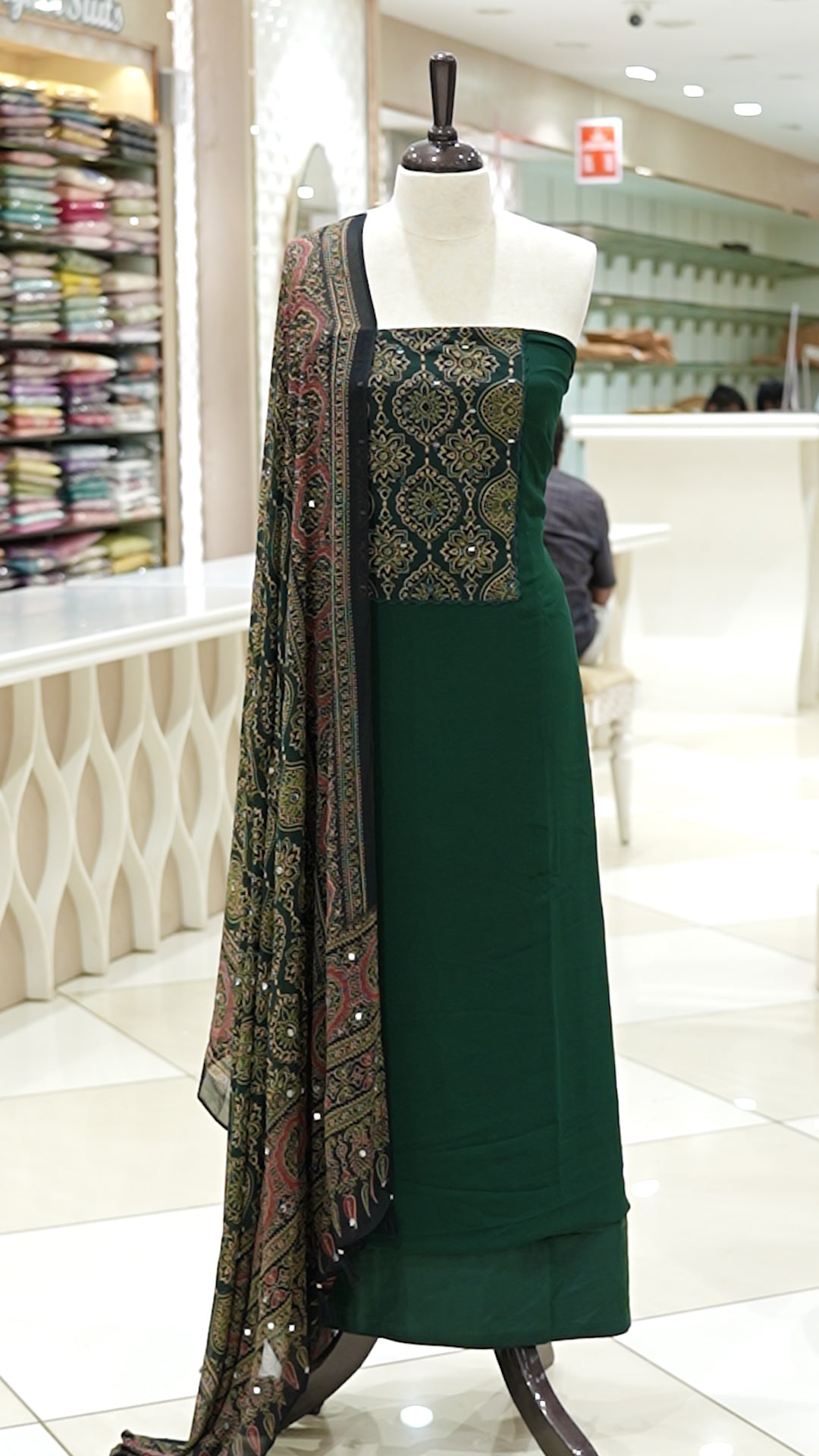 Bottle Green Georgette salwar material featuring Ajrakh print with mirror work on the yoke, paired with Ajrakh printed dupatta with mirror detailing and plain bottom.
