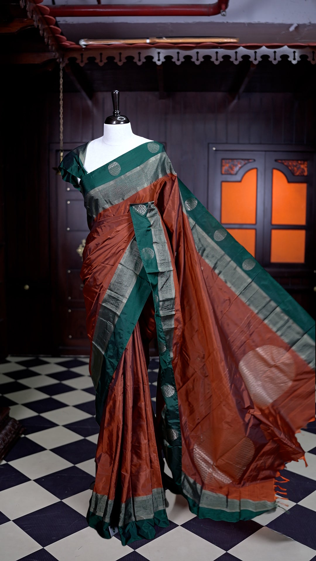 Burnt Orange colour Arani Silk saree featuring a plain body with elegant contrast Green borders, comes with a matching blouse piece.