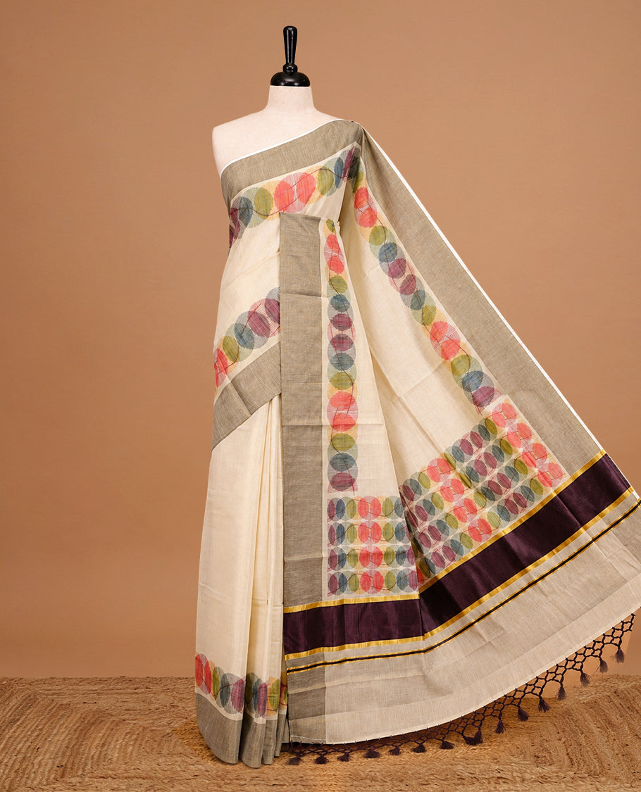 Cream Colour Tissue Kerala Saree Featuring Multicolour Circular Prints Along The Border And Pallu, Complemented By A Brown Border With Traditional Gold Zari Accents, Paired With A Matching Blouse Piece.