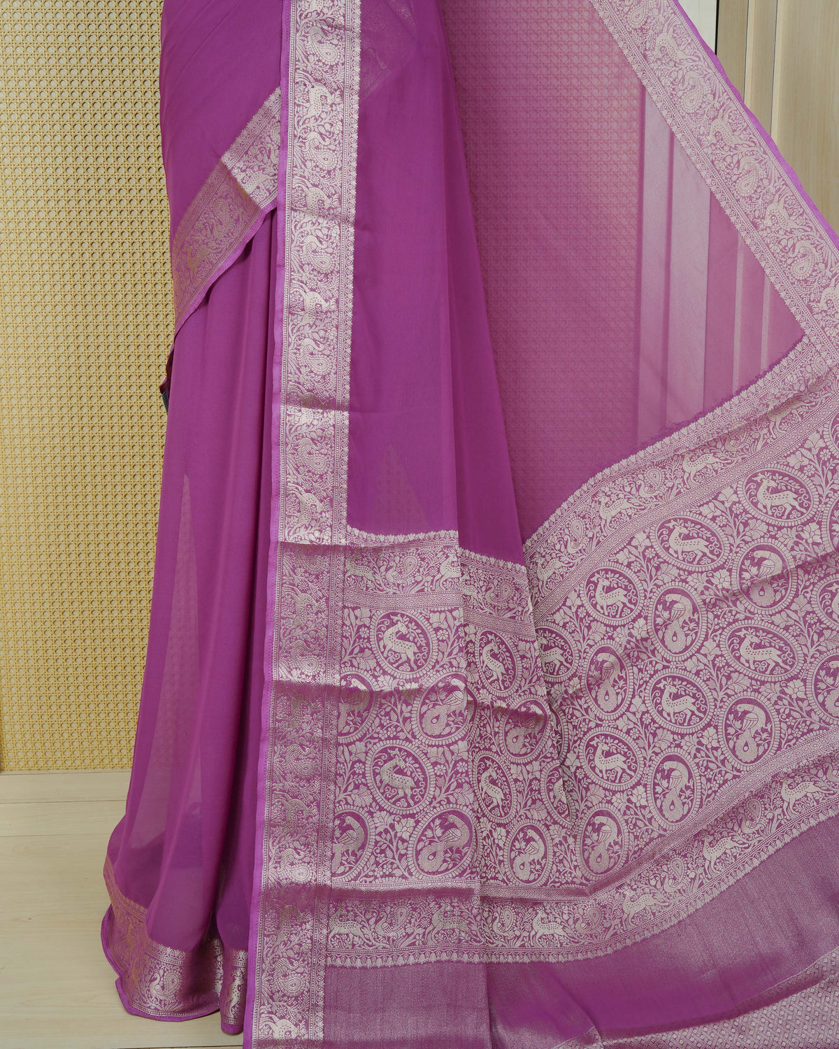 Plum colour georgette saree having plain body, peacock & deer gold zari detailed border, comes with matching blouse piece