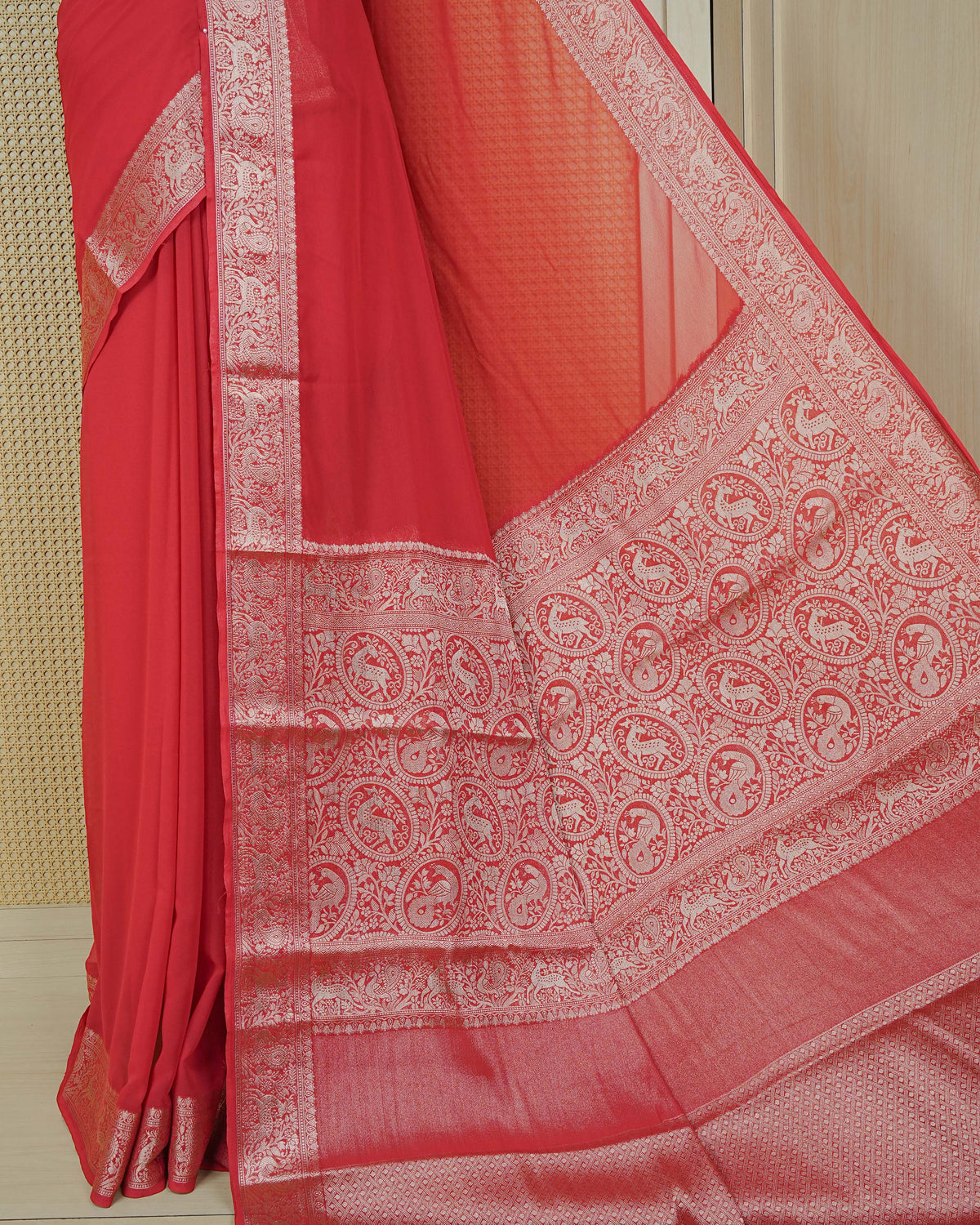 Vibrant red colour georgette saree having plain body, peacock & deer gold zari detailed border, comes with matching blouse piece