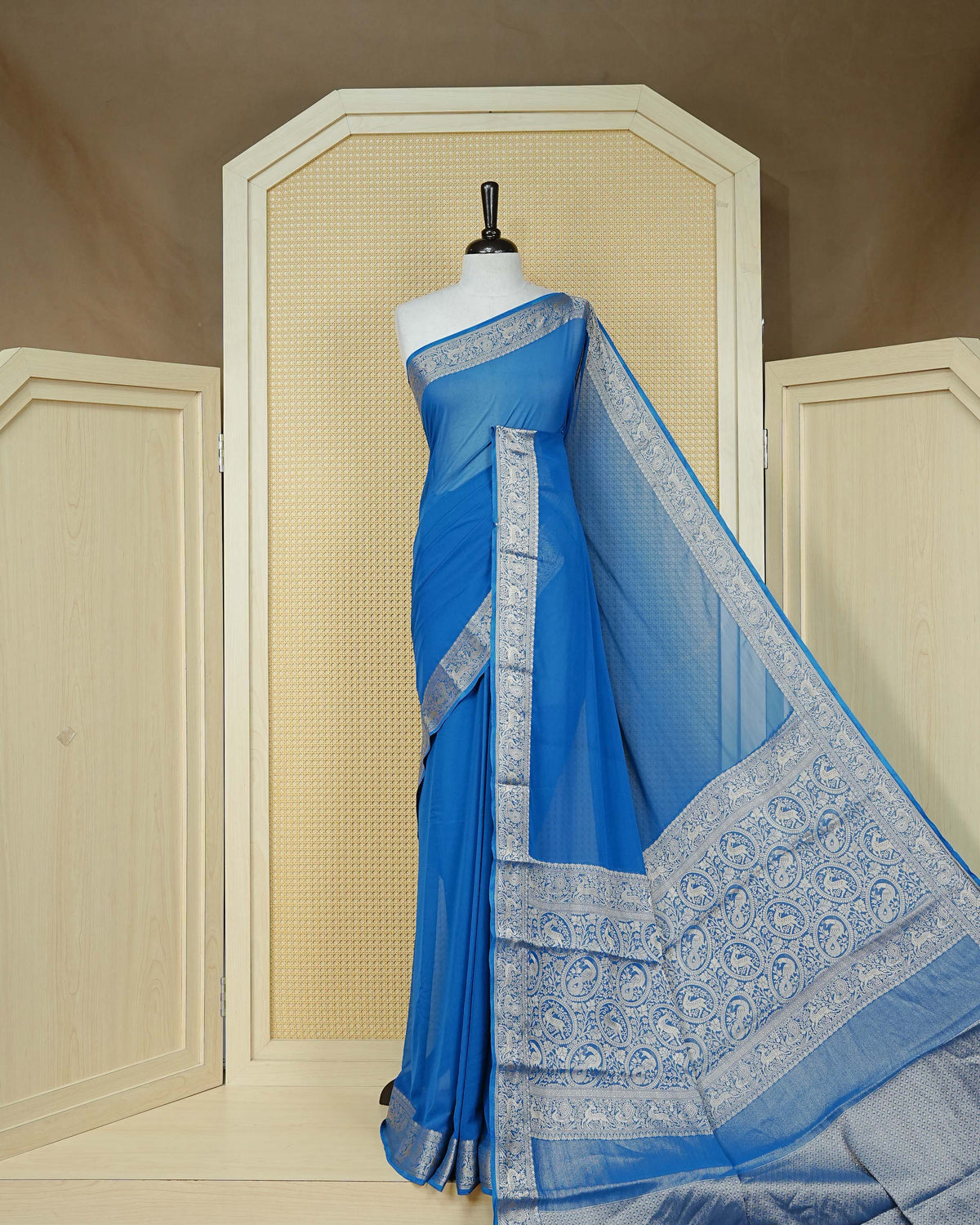 Royal blue colour georgette saree having plain body, peacock & deer gold zari detailed border, comes with matching blouse piece
