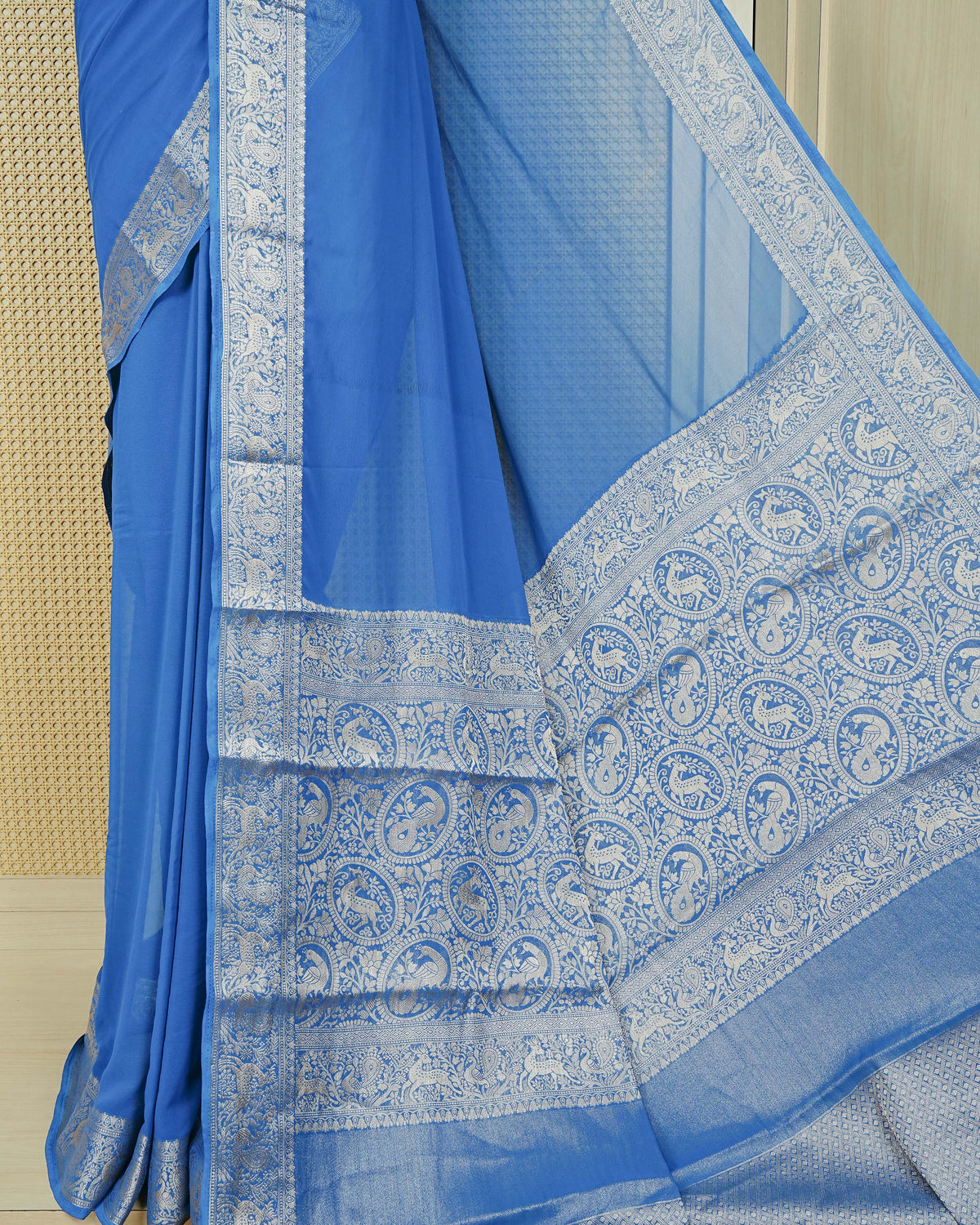 Royal blue colour georgette saree having plain body, peacock & deer gold zari detailed border, comes with matching blouse piece