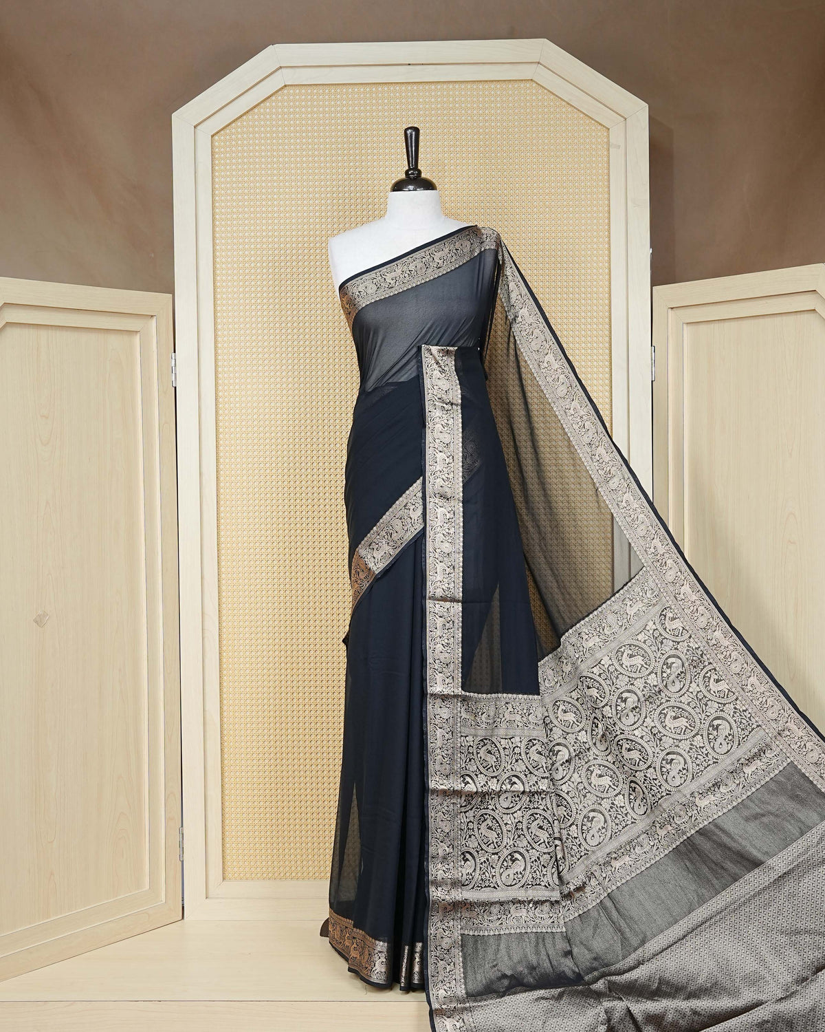 Black colour georgette saree having plain boy, Floral Gold zari detailed pattern border, comes with matching blouse piece