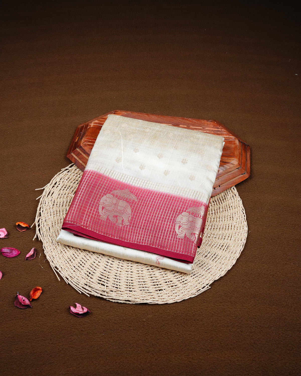 Cream colour Tussar silk saree Featuring buttas on body, complemented by Contrast maroon colour gold zari check pattern with elephant motifs on border, paired with matching blouse piece.