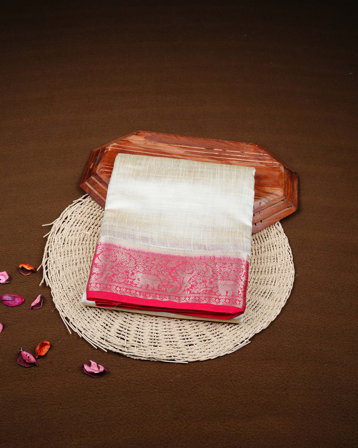 Cream colour Tussar silk saree Featuring Plain body, complemented by Contrast red colour gold zari elephant & tree motifs on border, paired with matching blouse piece.